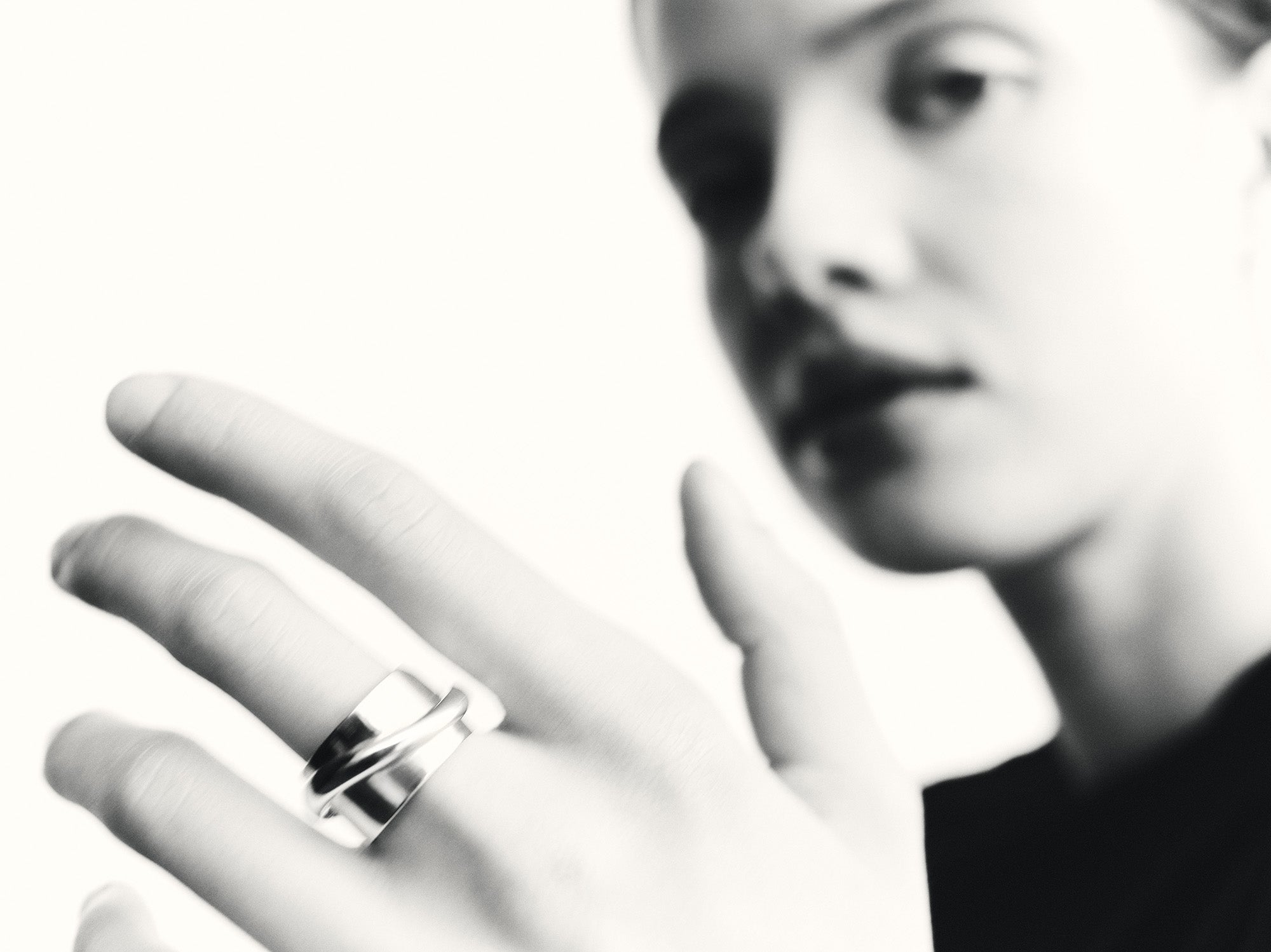 Woman wearing AGMES .925 sterling silver Large Arden Cigar Band Ring on middle finger, black & white