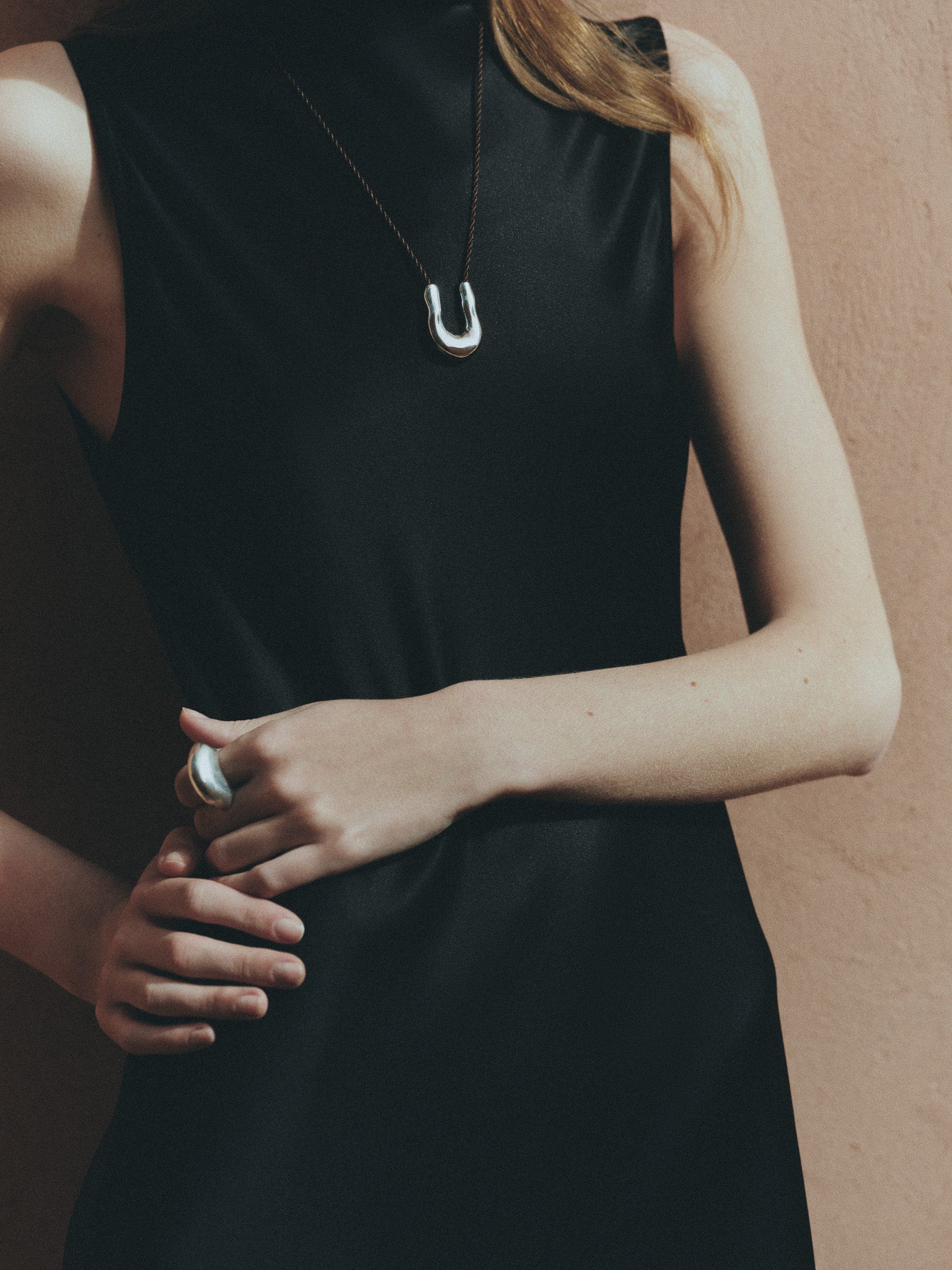 Woman wearing AGMES .925 Sterling Silver Jouve Ring and Wishbone Pendant. 