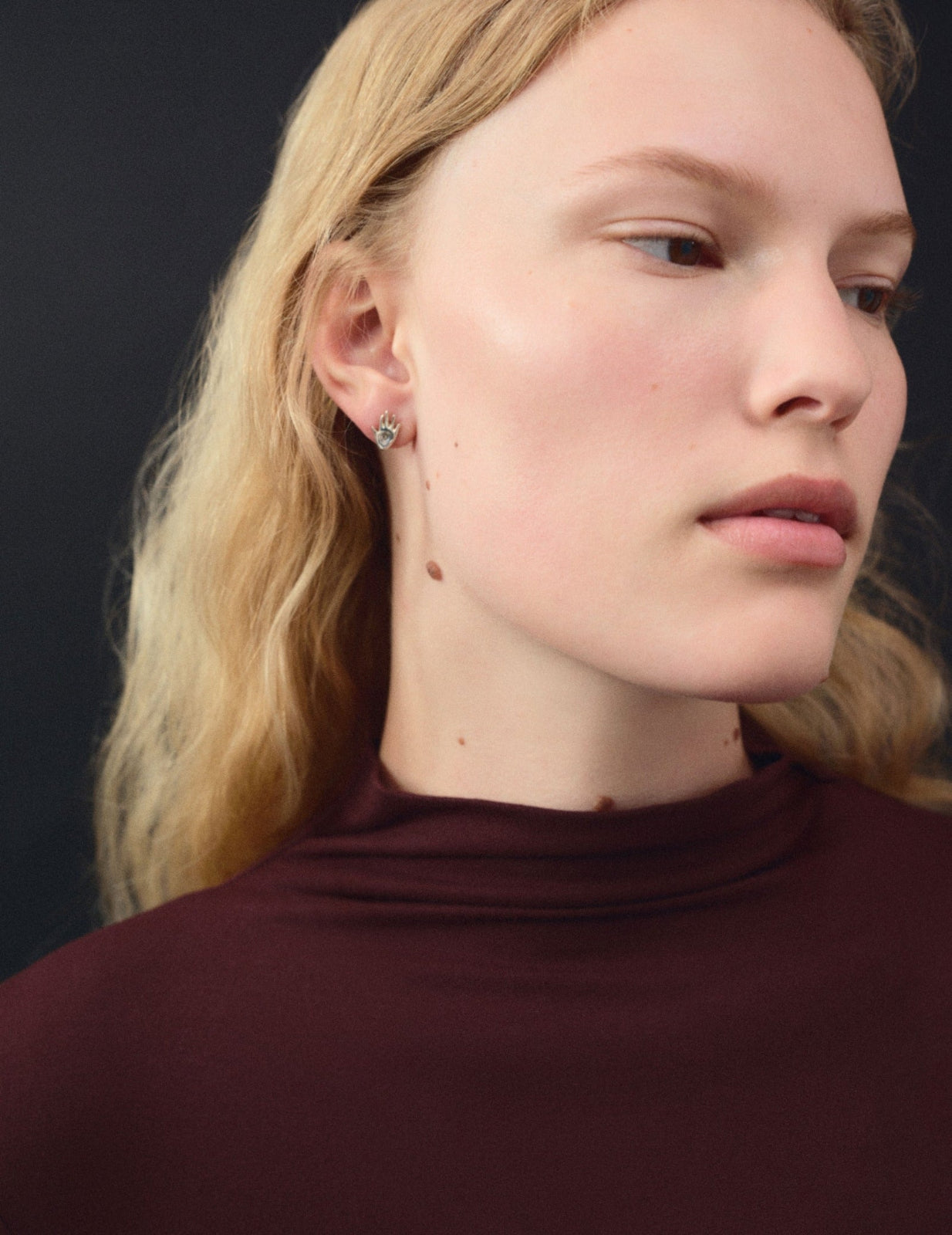 Woman wearing AGMES .925 sterling silver mini hand shaped stud earrings. Mini Dali Stud Earrings.