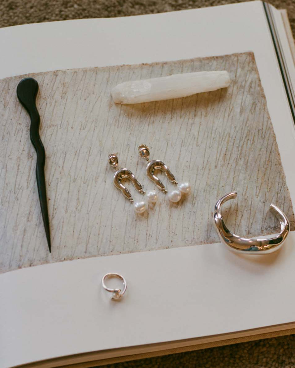.925 sterling silver Small Imogene Earrings laying on book, still life