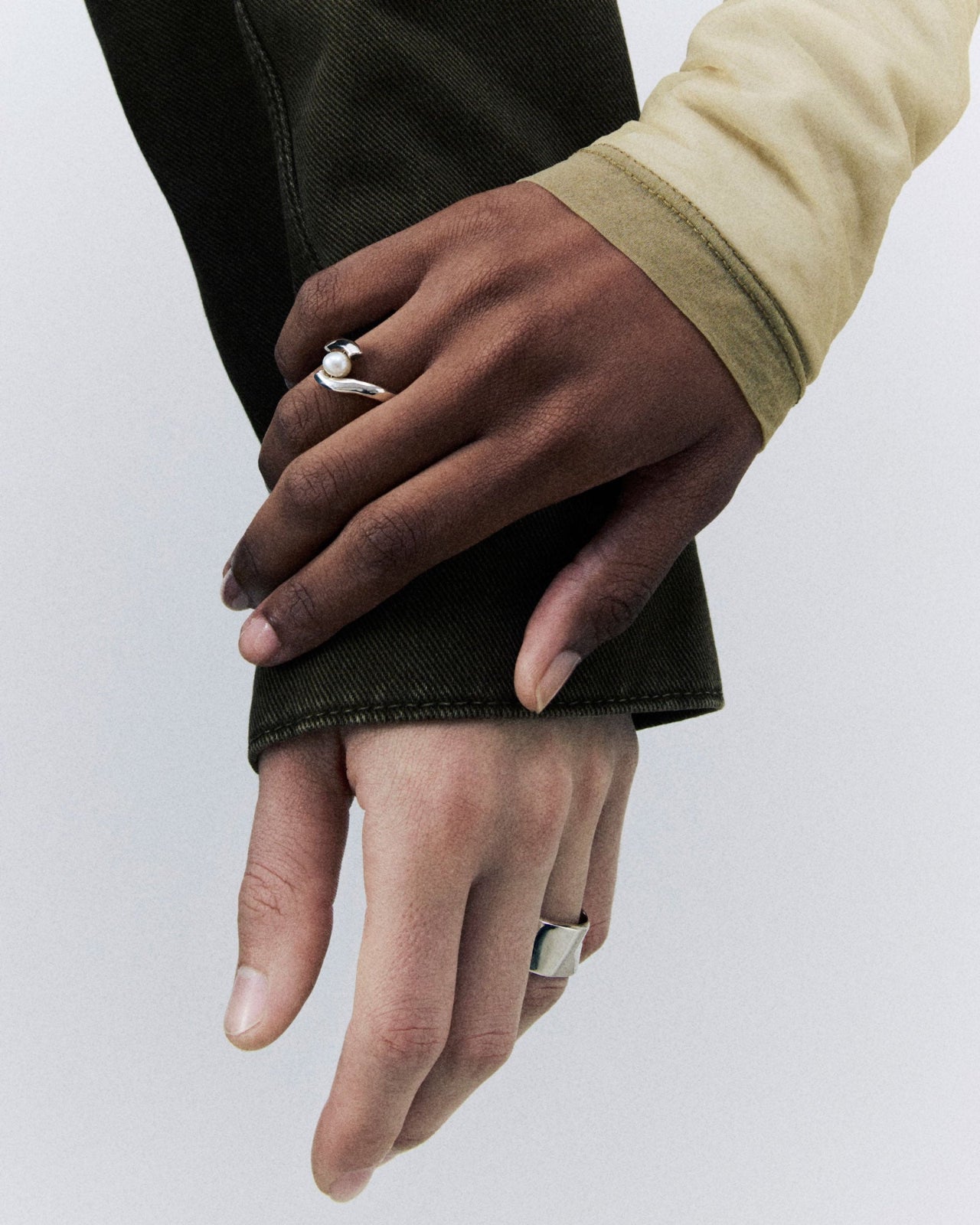 Models wearing .925 sterling silver wide astrid cigar band and claire ring with pearl stone
