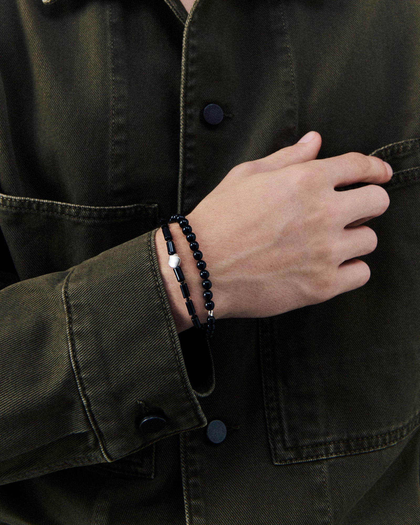 Male model wearing onyx stone and .925 sterling silver AGMES Willa Bracelet