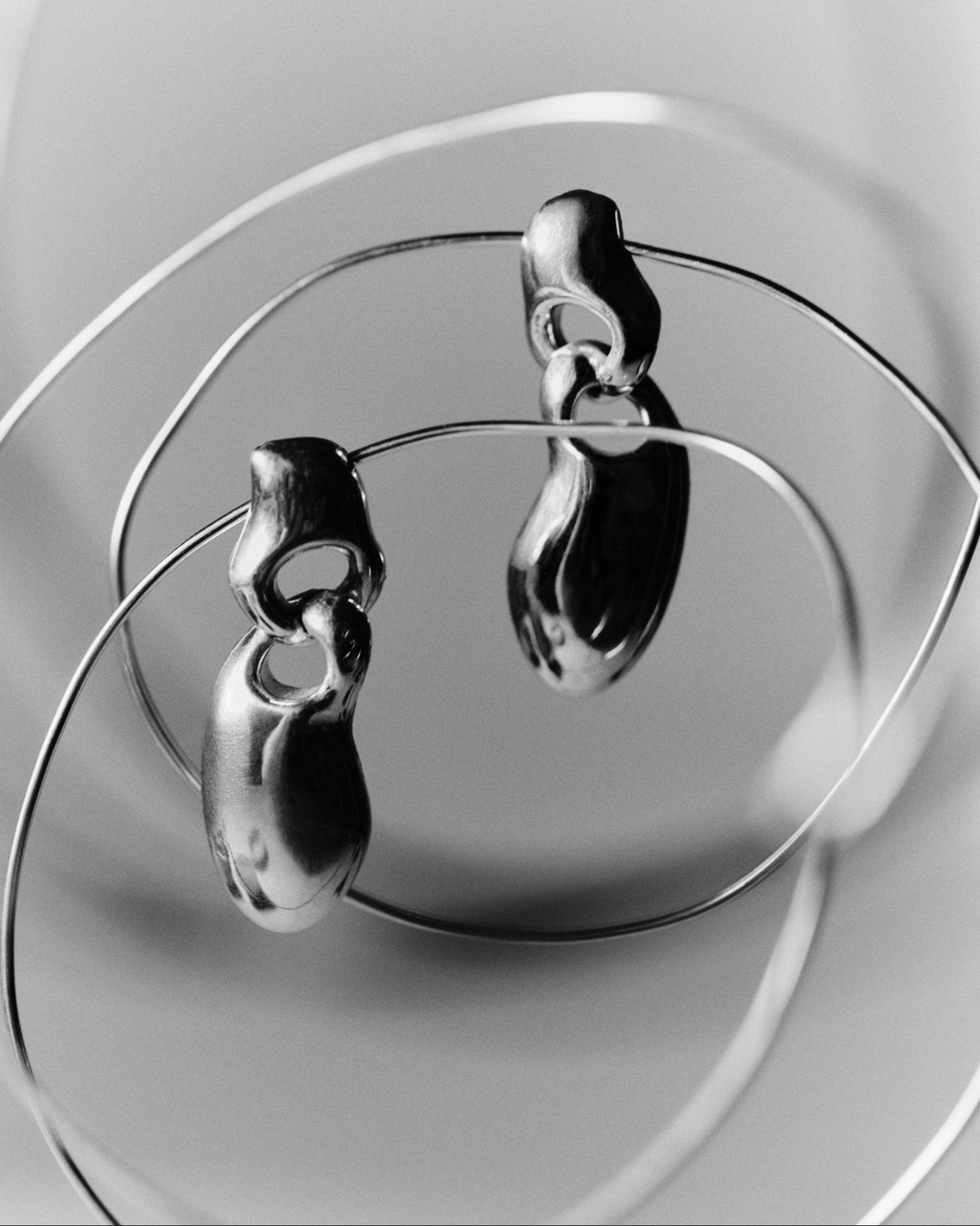 AGMES .925 sterling silver sculptural drop Francesca Earrings hanging on meaatl wire.