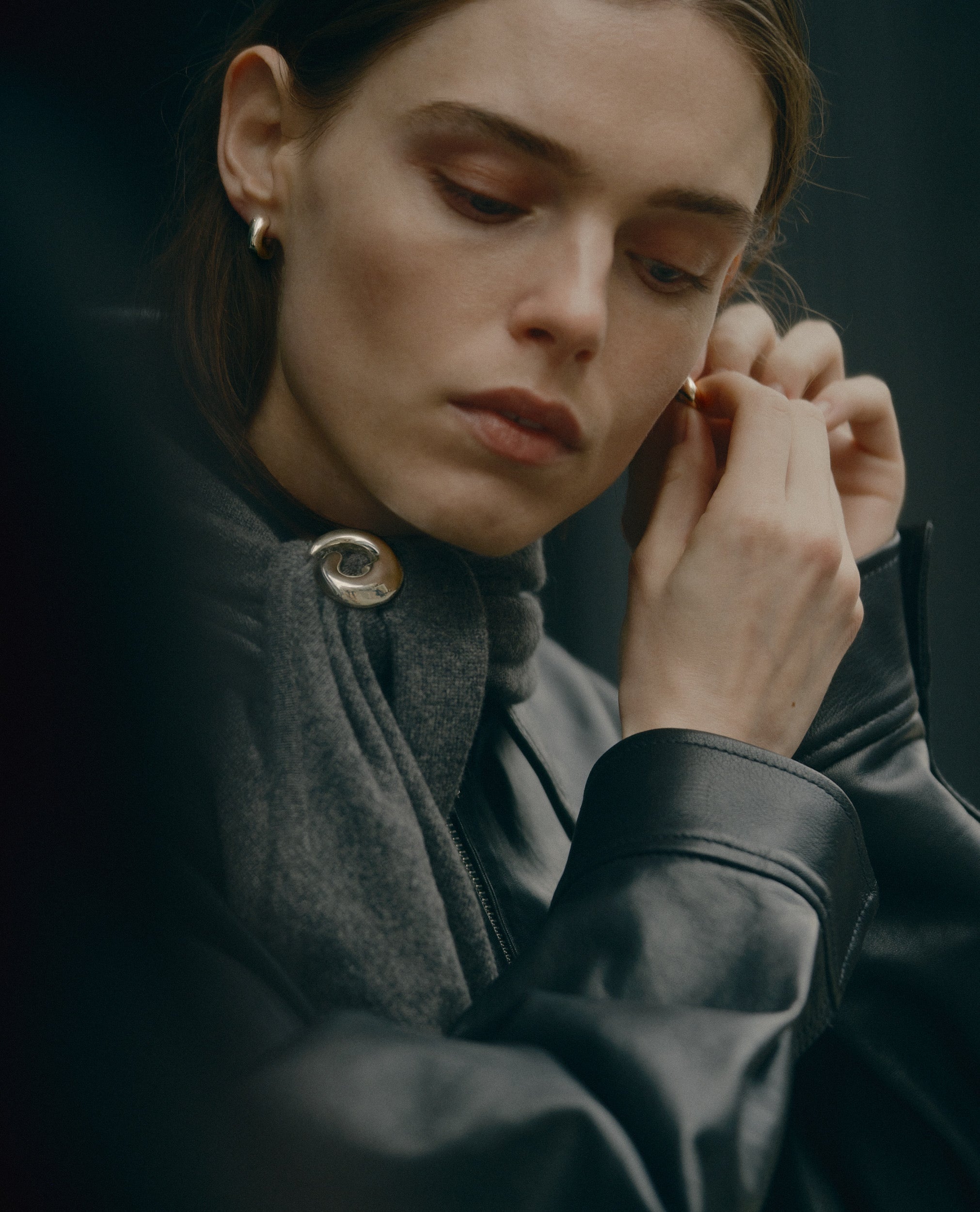 Model putting on .925 sterling silver AGMES small dahlia hoops