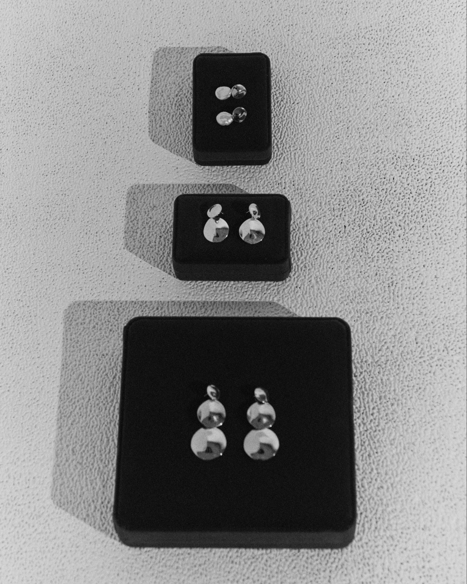 .925 sterling silver circular short stella earrings and 18k gold vermeil stella earrings laying flat in boxes