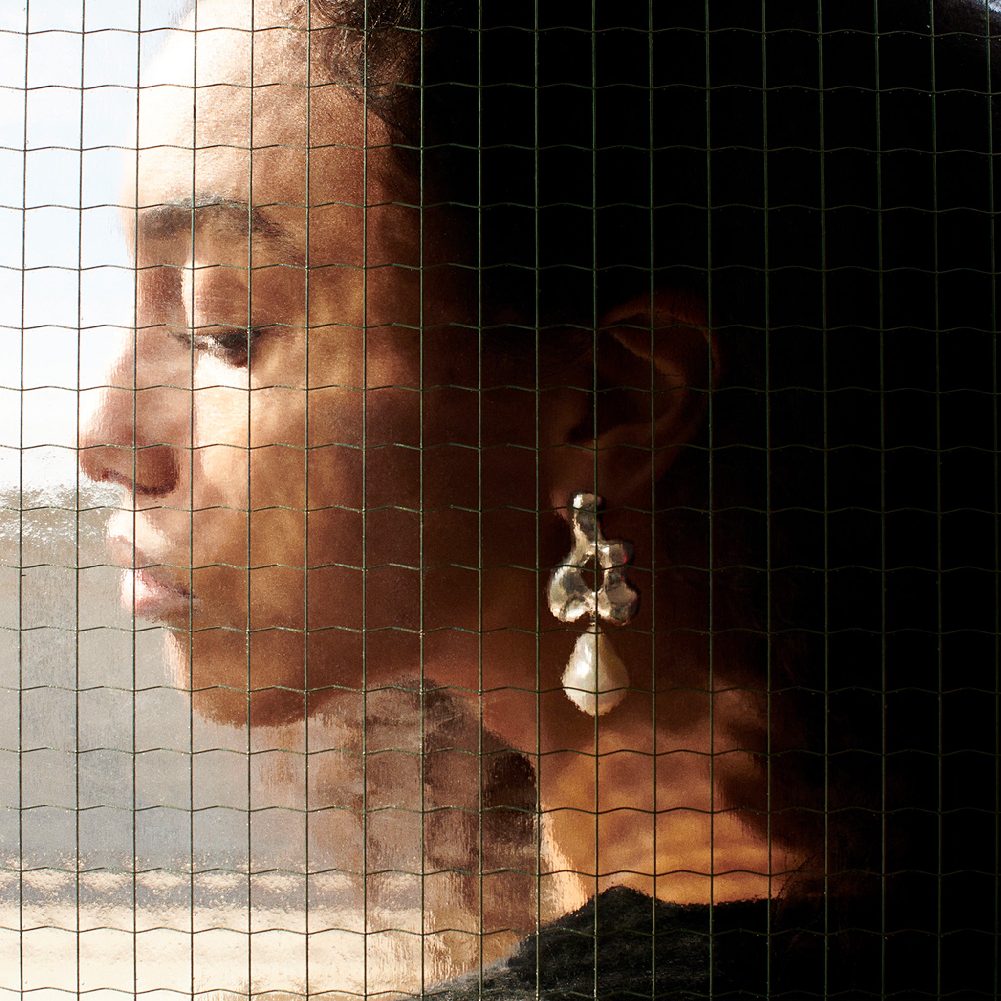 Woman wearing AGMES 0.925 sterling silver sculpted earrings with freshwater pearl drop. Simone Bodmer-Turner.