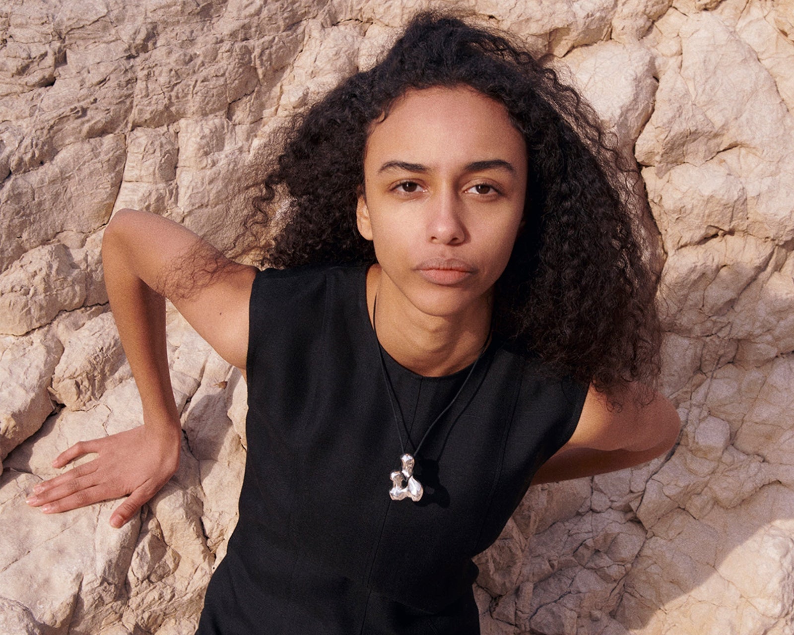 Woman wearing AGMES .925 Sterling Silver sculpted pendant on black suede cord. Simone Bodmer-Turner.