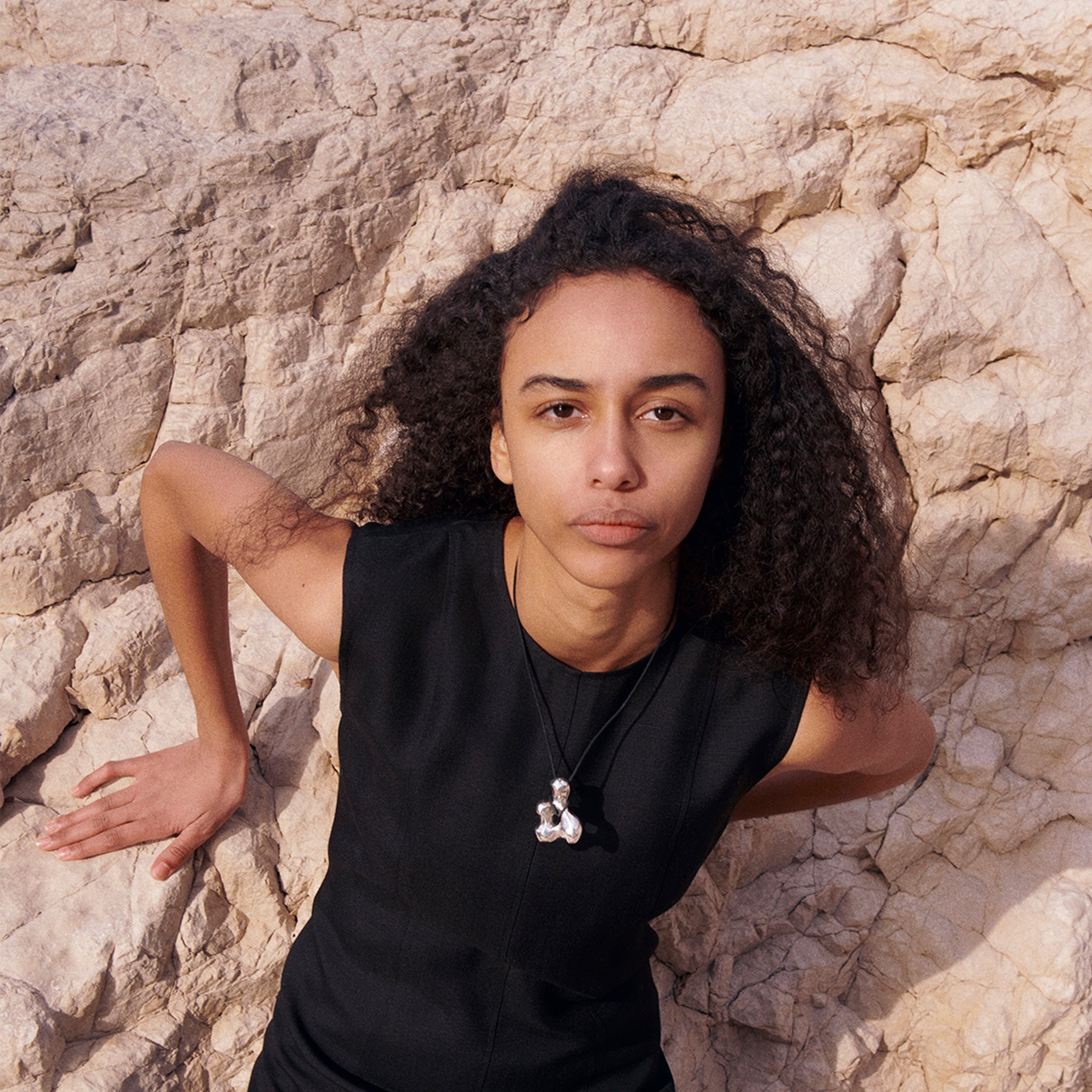 Woman wearing AGMES .925 Sterling Silver sculpted pendant on black suede cord. Simone Bodmer-Turner.