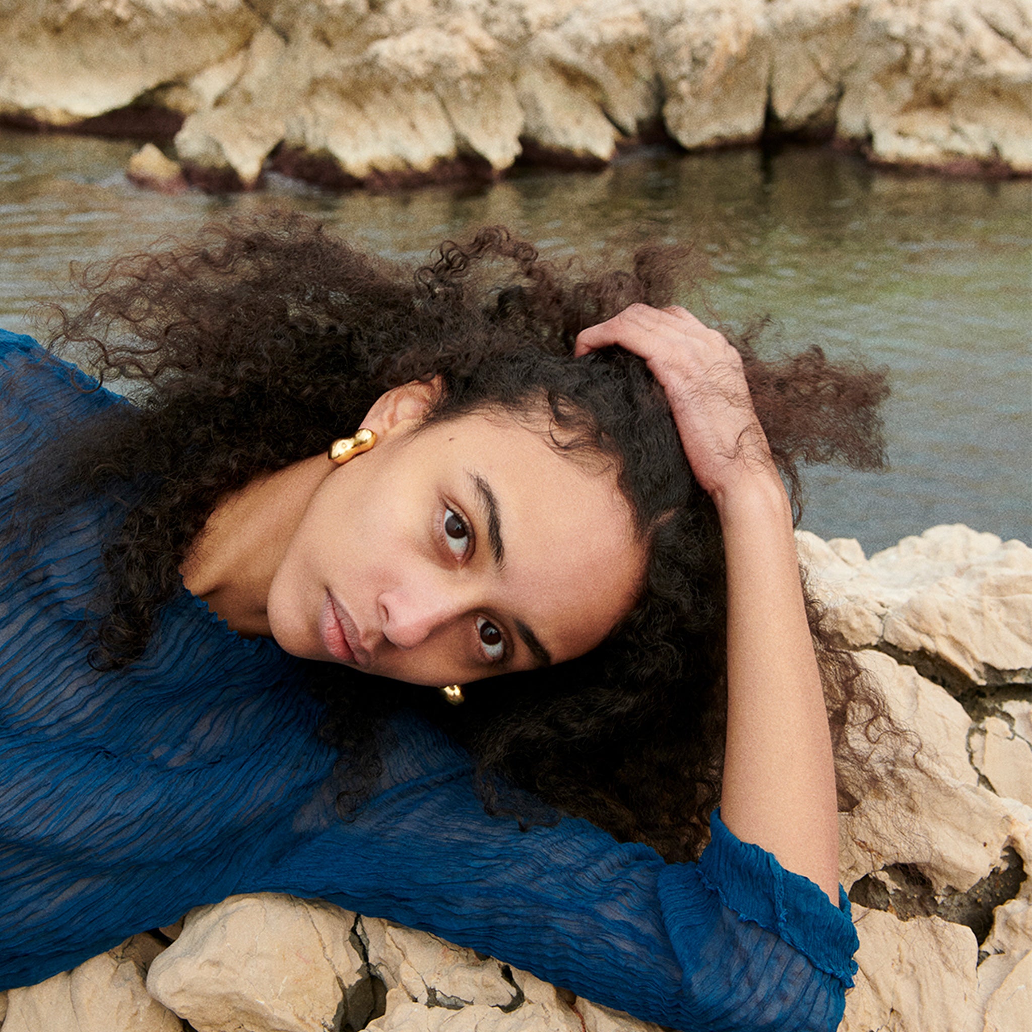 Woman wearing AGMES 18k gold vermeil sculpted bubble hoop earrings. Simone Bodmer-Turner.