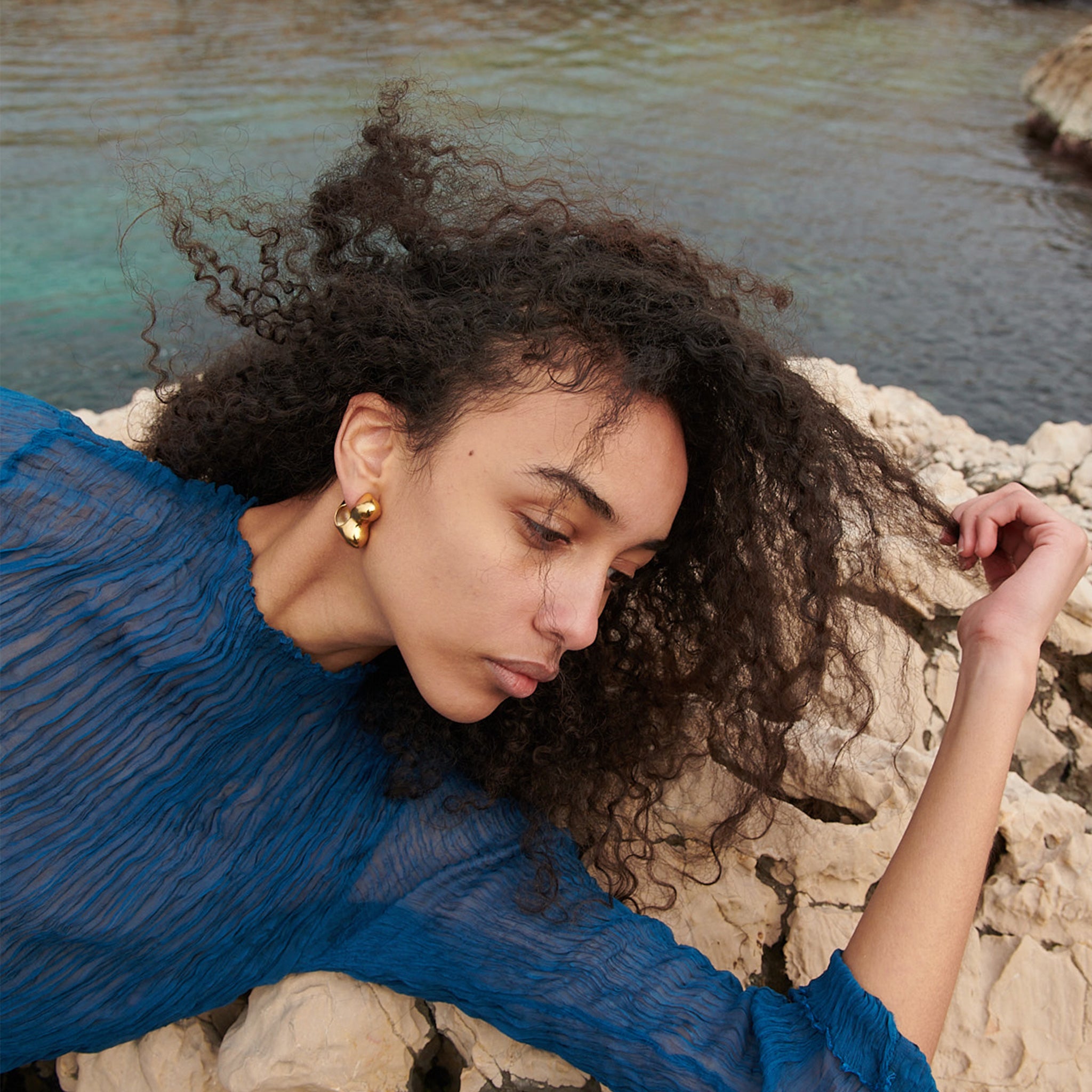 Woman wearing AGMES 18k gold vermeil sculpted bubble hoop earrings. Simone Bodmer-Turner.