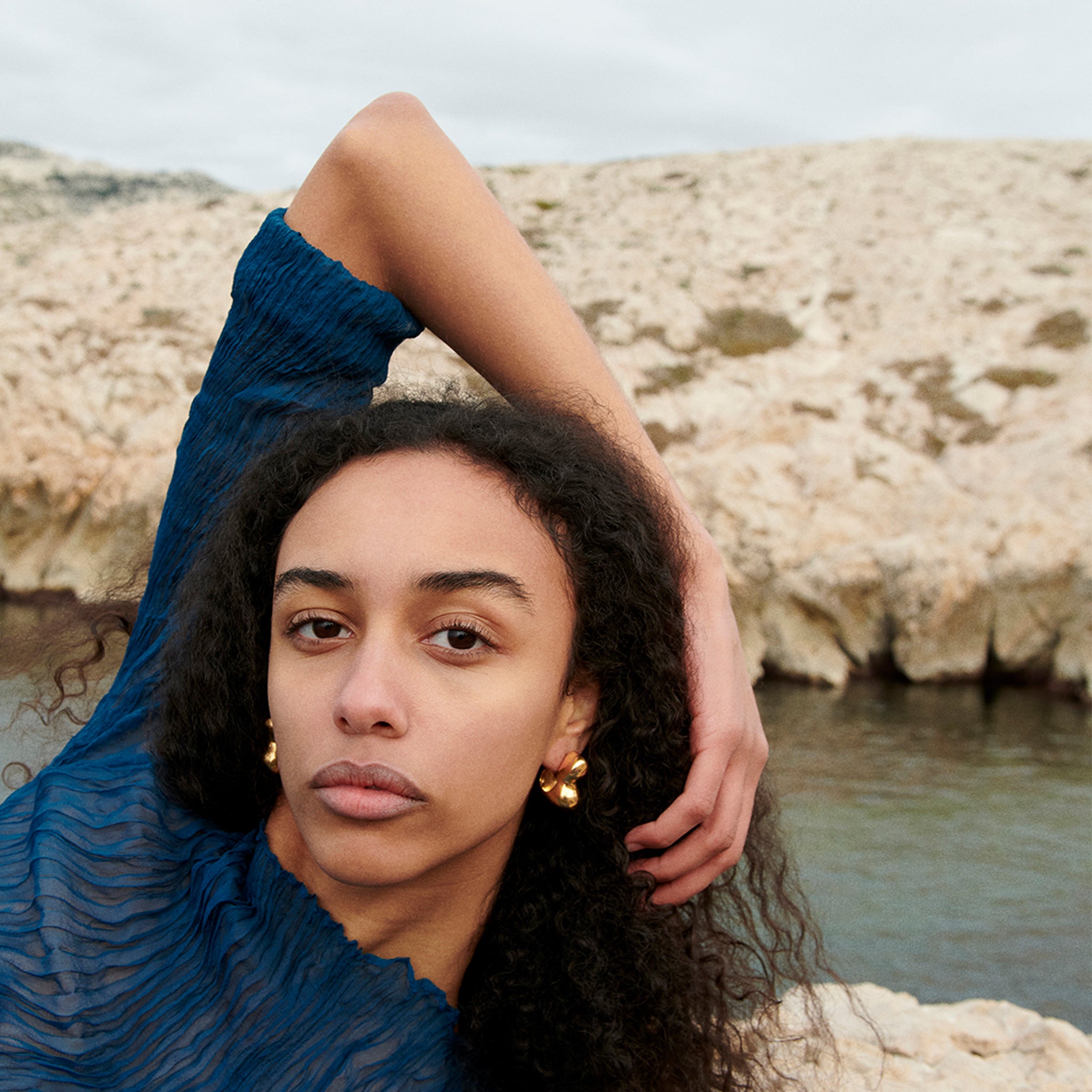 Woman wearing AGMES 18k gold vermeil sculpted bubble hoop earrings. Simone Bodmer-Turner.