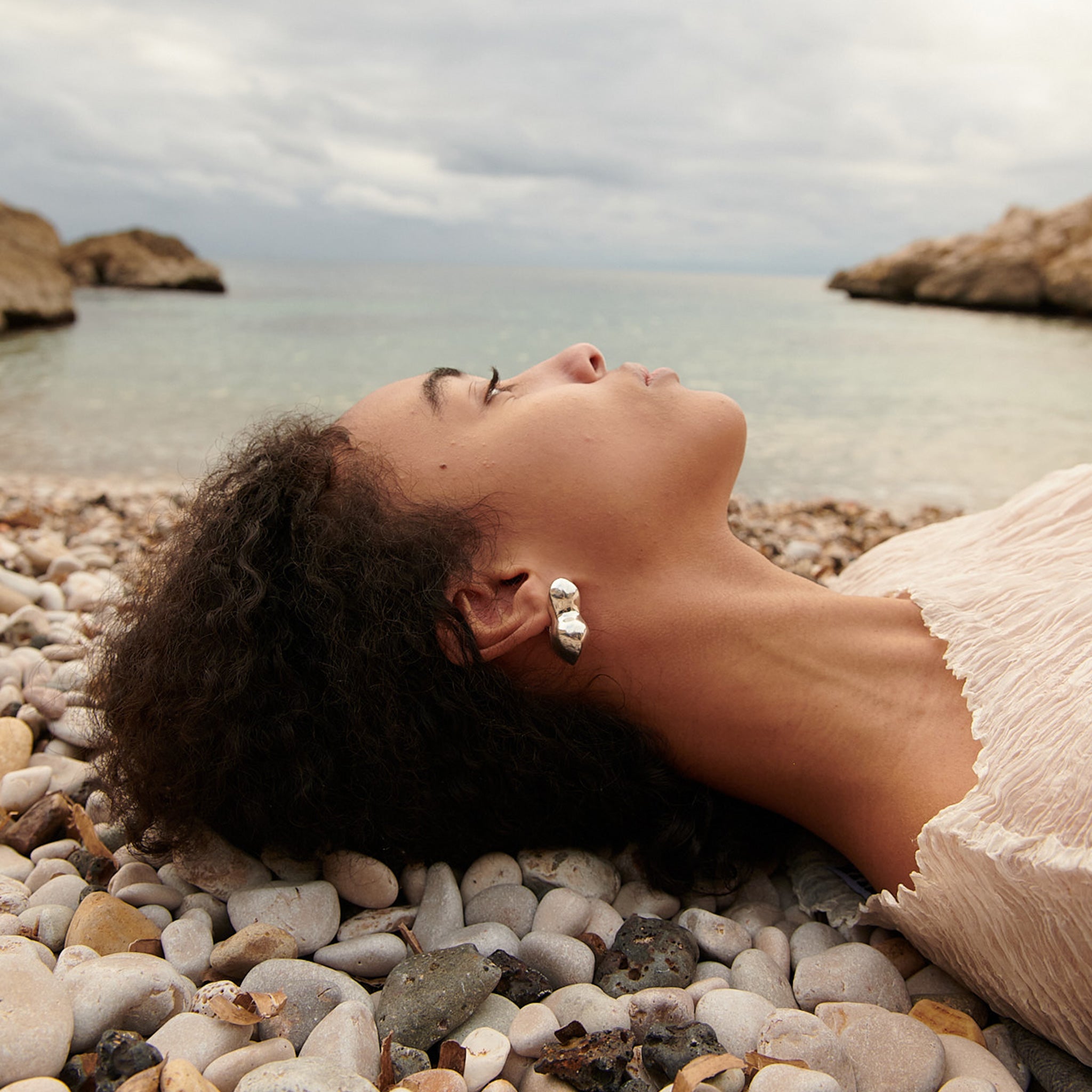 Woman wearing AGMES 0.925 sterling silver sculpted bubble hoop earrings. Simone Bodmer-Turner.