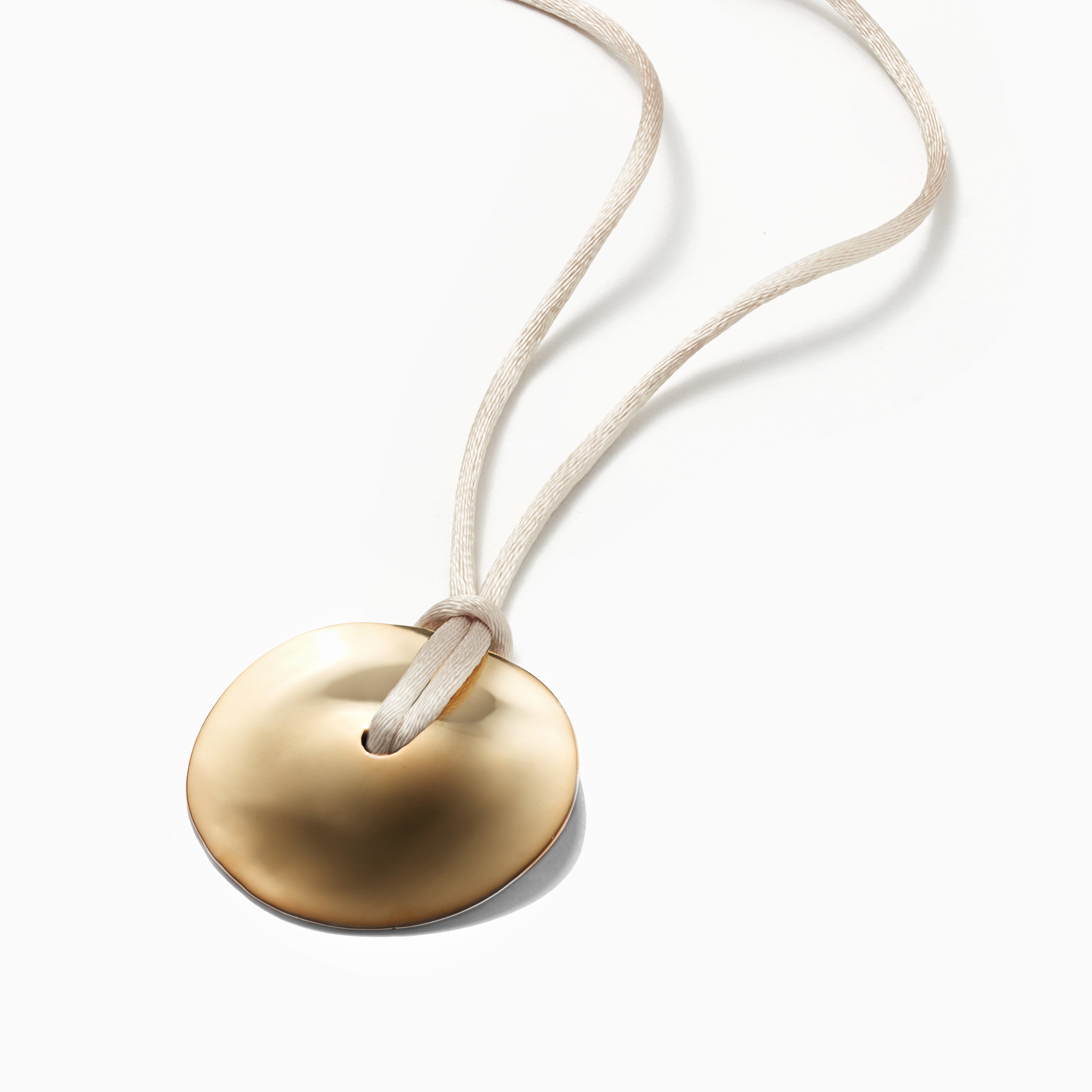 AGMES 18k Gold Vermeil Cora Pendant paired with Ivory Silk Cord. Round Pendant Necklace on white background.