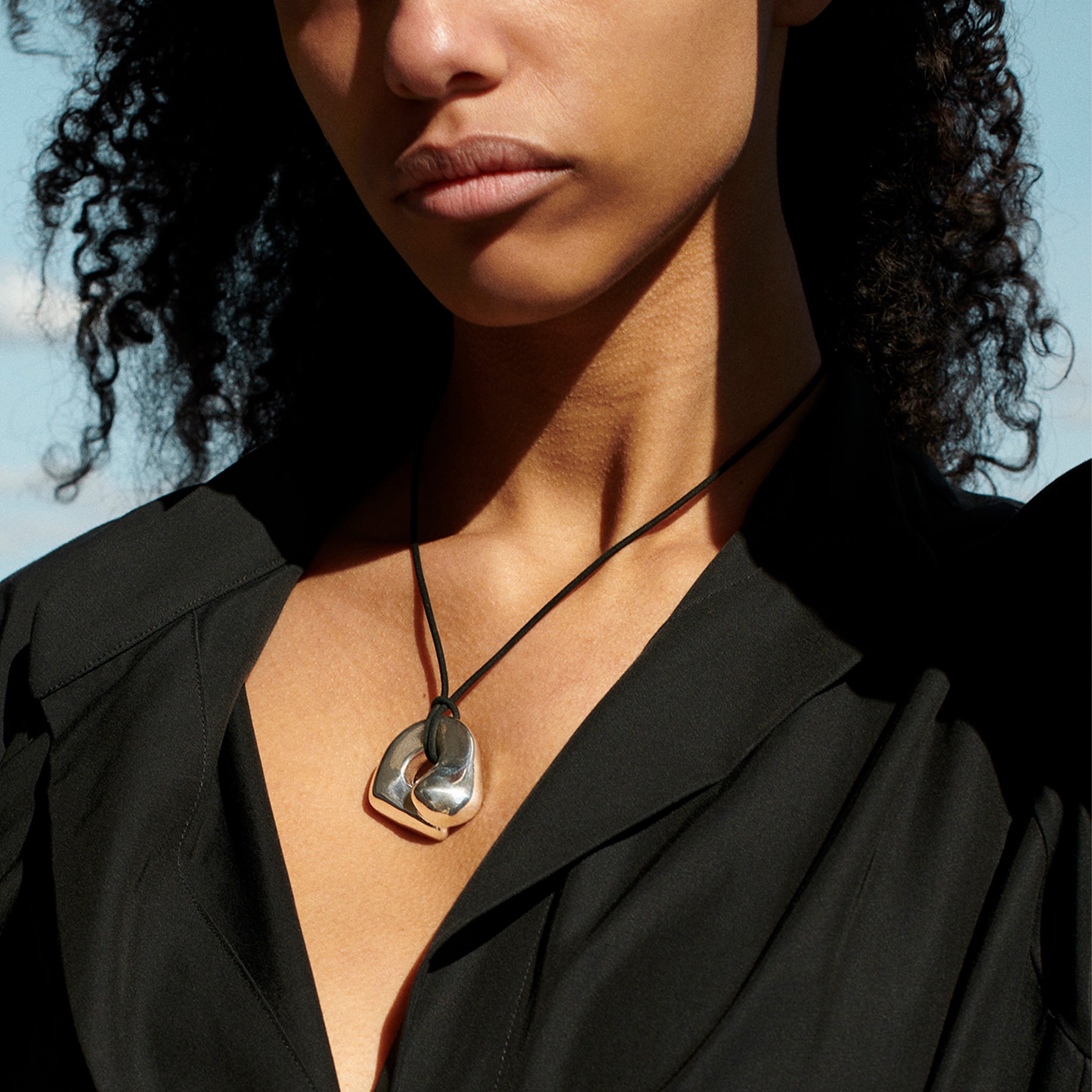 Woman wearing AGMES .925 Sterling Silver Structural Gertrude Pendant with Black Suede Cord. Simone Bodmer-Turner. 