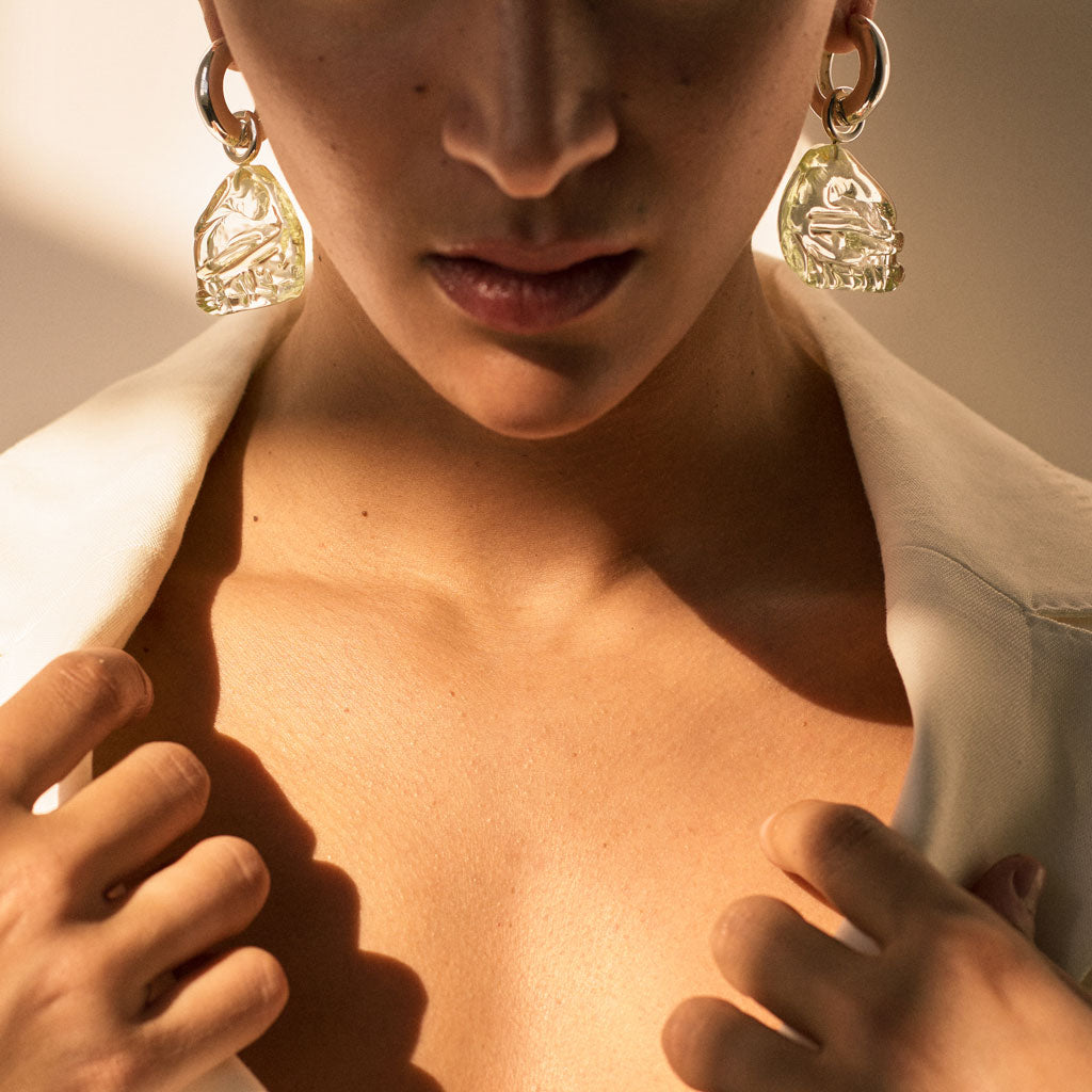 Woman wearing AGMES 0.925 sterling silver hoop earrings with green Handblown Venetian Glass drop.