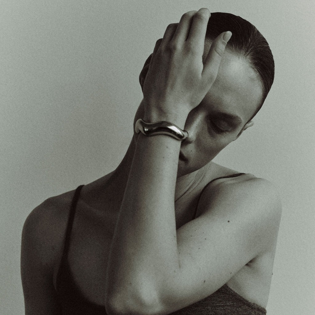 Woman wearing AGMES 0.925 sterling silver large Astrid sculpted cuff bracelet.