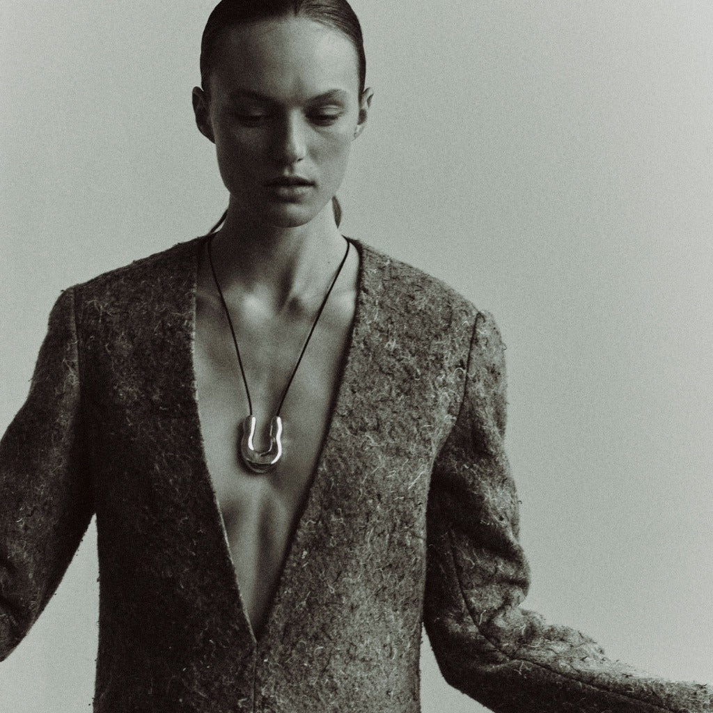 Woman wearing AGMES 0.925 Sterling Silver Large Wishbone Pendant on Black Suede Cord.  