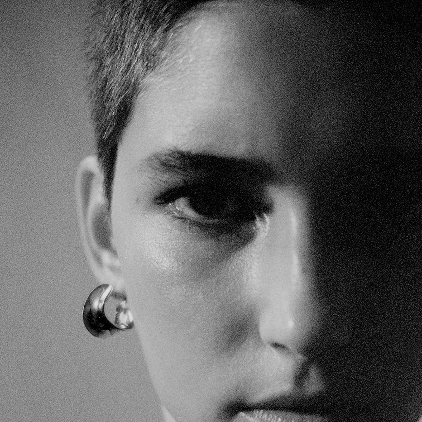 Woman wearing AGMES 18k gold vermeil mini twist hoop earrings.