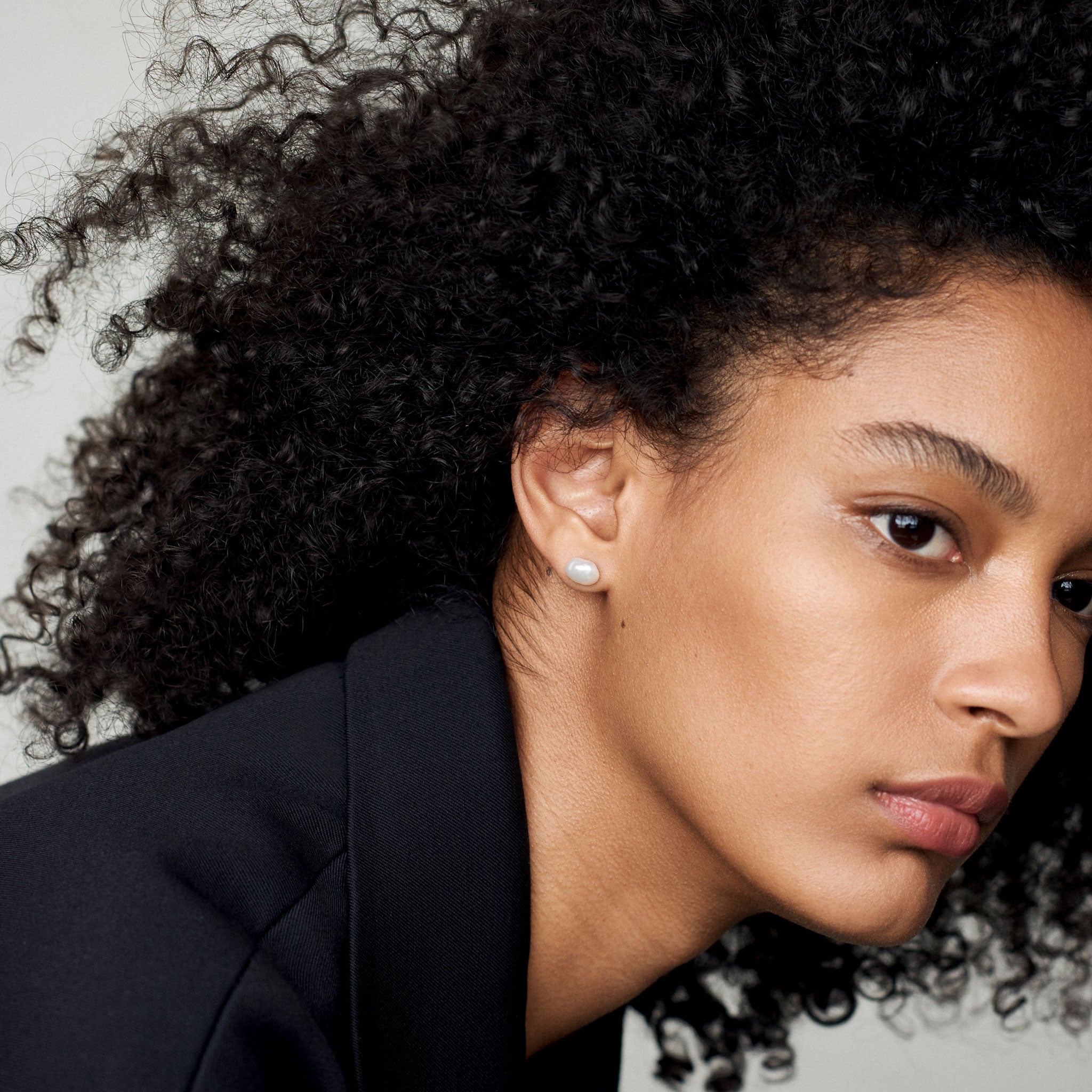 Woman wearing AGMES pearl stud earrings.