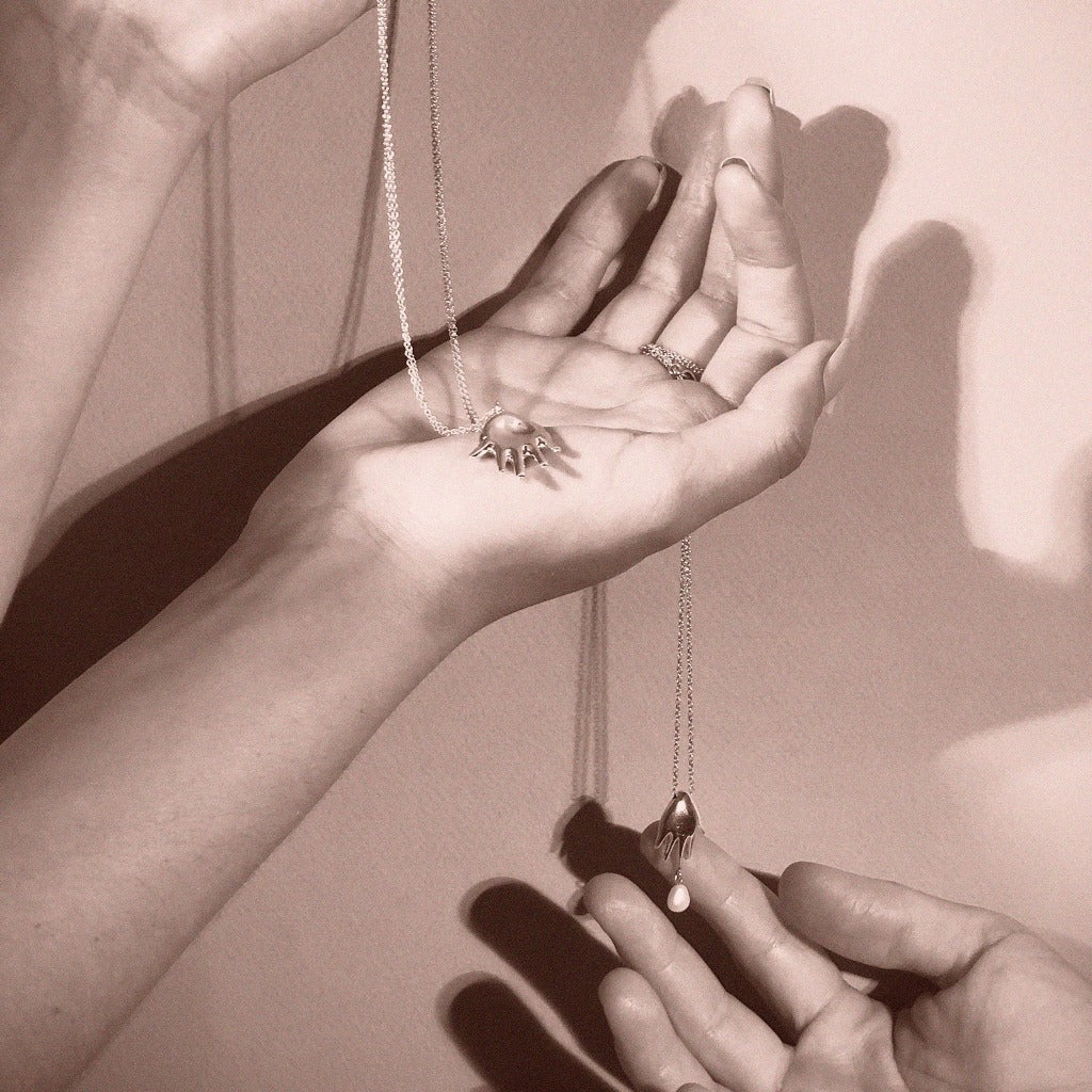 AGMES .925 Sterling Silver Small Dali Pendant on .925 Sterling Silver Chain. Abstract Hand Pendant Necklace. Displayed in person's hands.