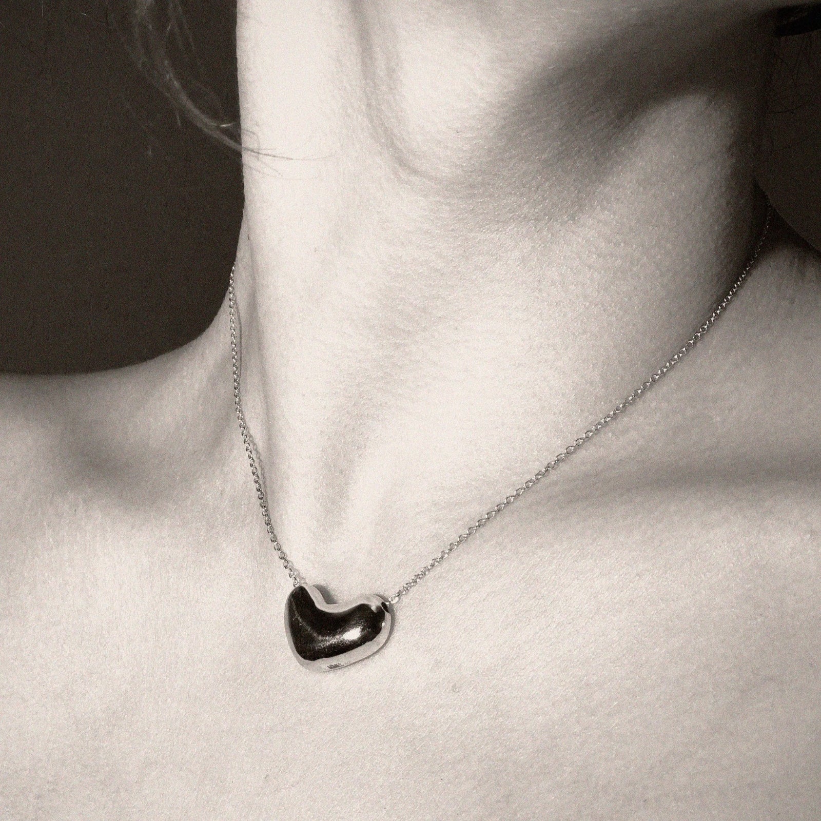 Person wearing AGMES .925 Sterling Silver Small Sculpted Heart Pendant on chain Necklace. 