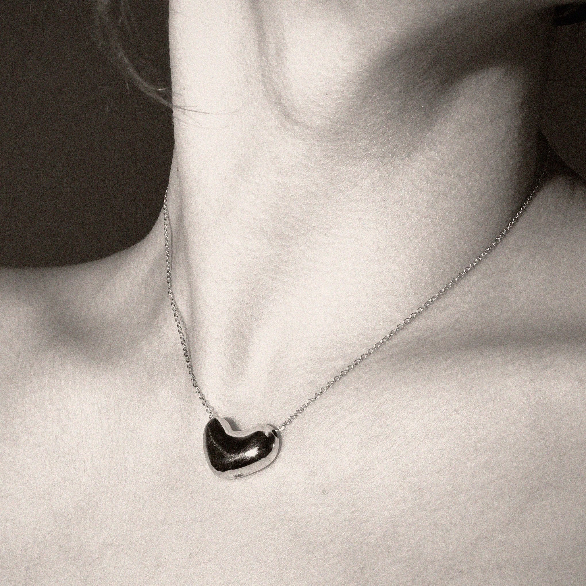 Person wearing AGMES .925 Sterling Silver Small Sculpted Heart Pendant on chain Necklace. 