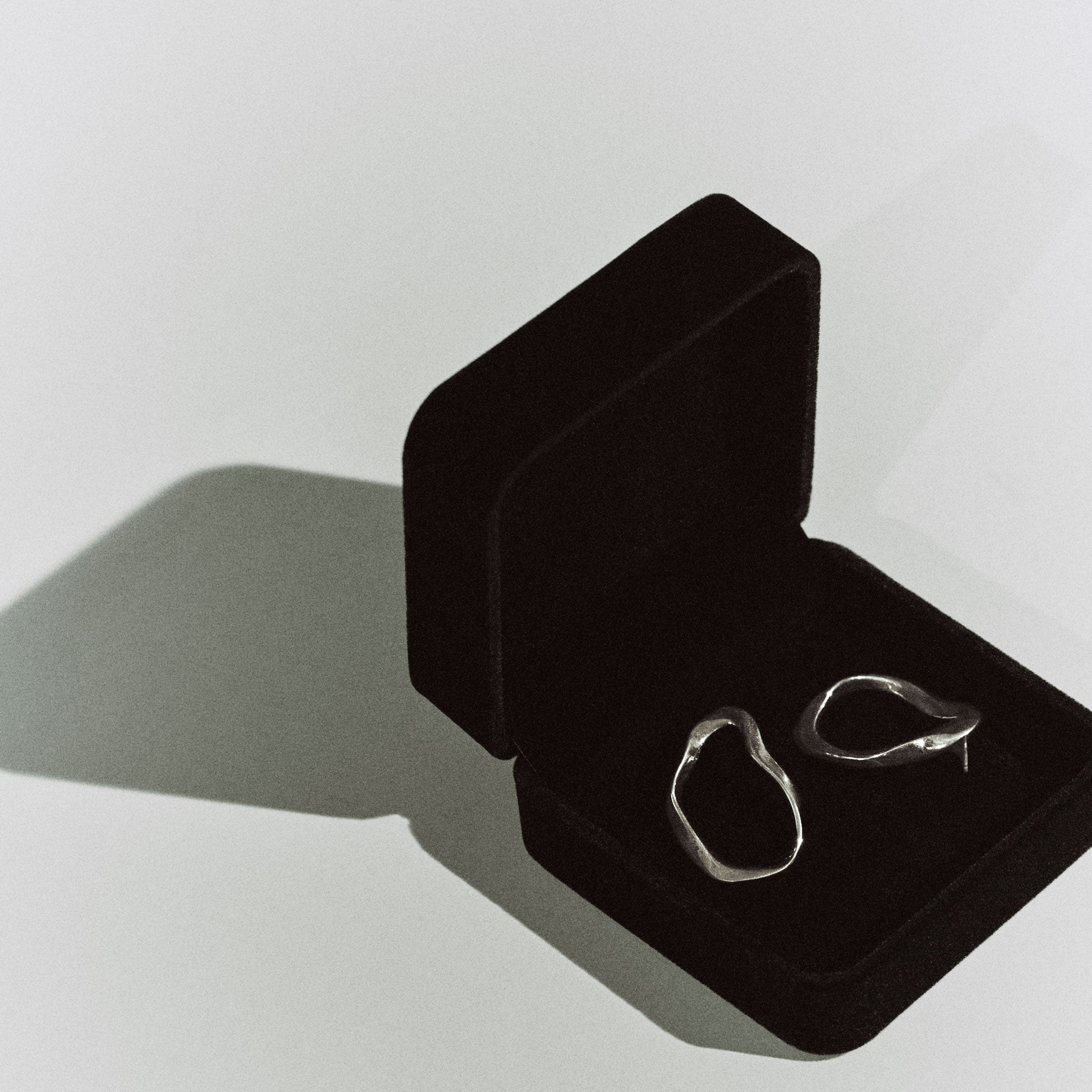 AGMES 0.925 sterling silver sculptural wavy small round hoop earrings.