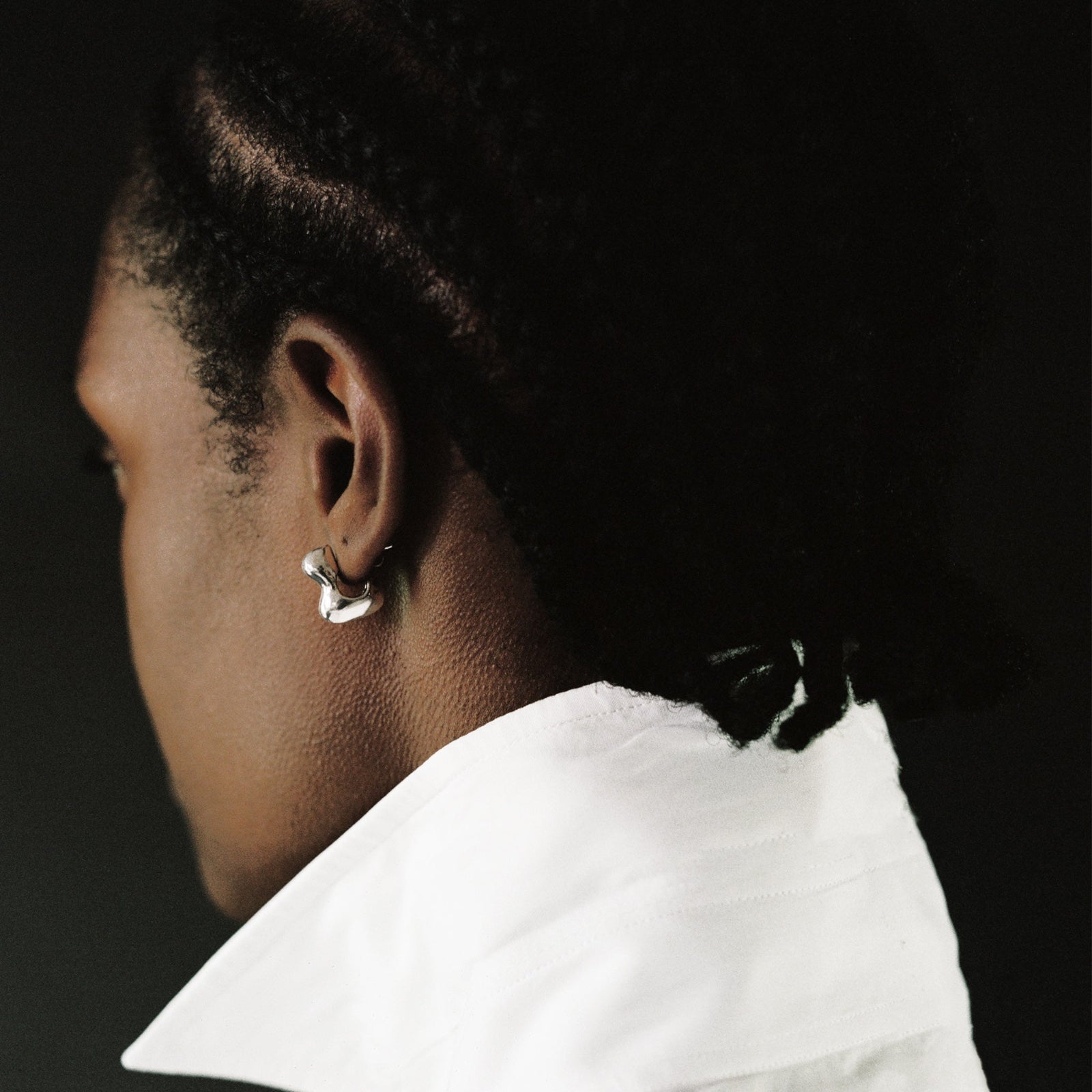 Woman wearing AGMES 0.925 sterling silver sculpted small bubble hoop earrings. Simone Bodmer-Turner.