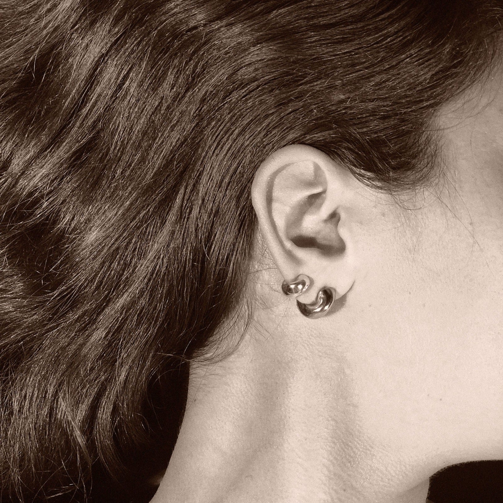 Woman wearing AGMES 0.925 sterling silver and yellow gold vermeil small Dahlia hoop earrings set. Huggies