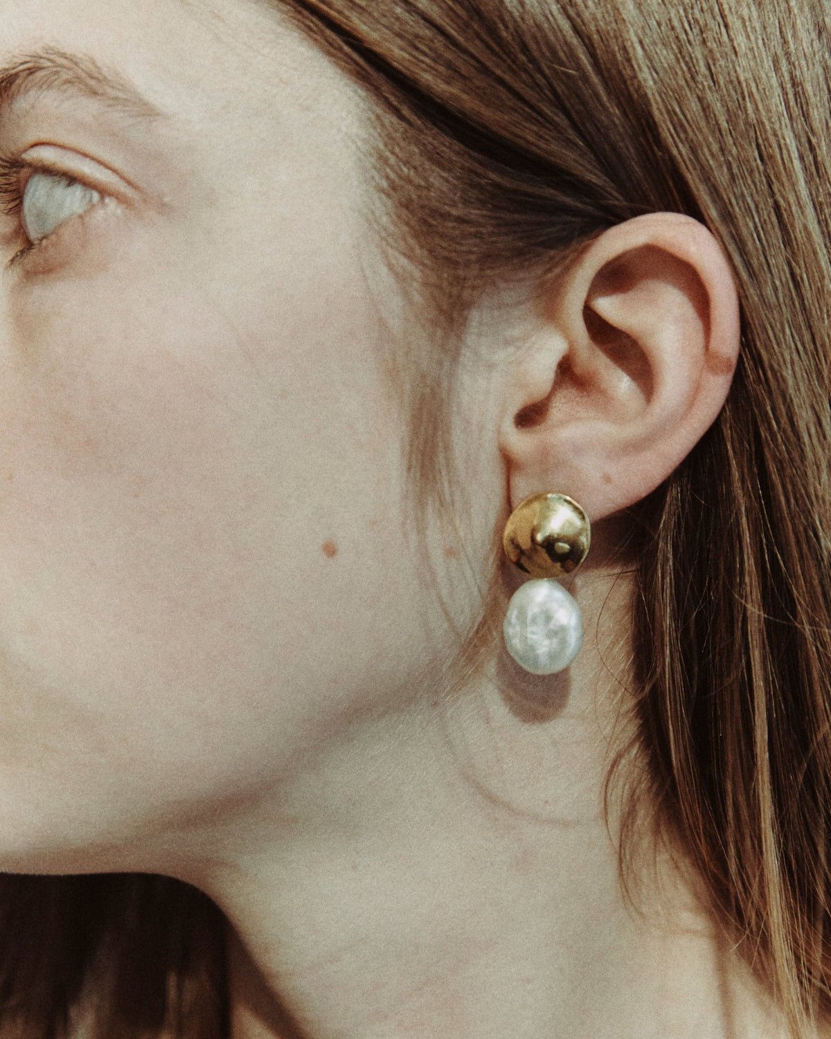 Woman wearing AGMES 18k gold vermeil small round earrings with freshwater pearl drop.