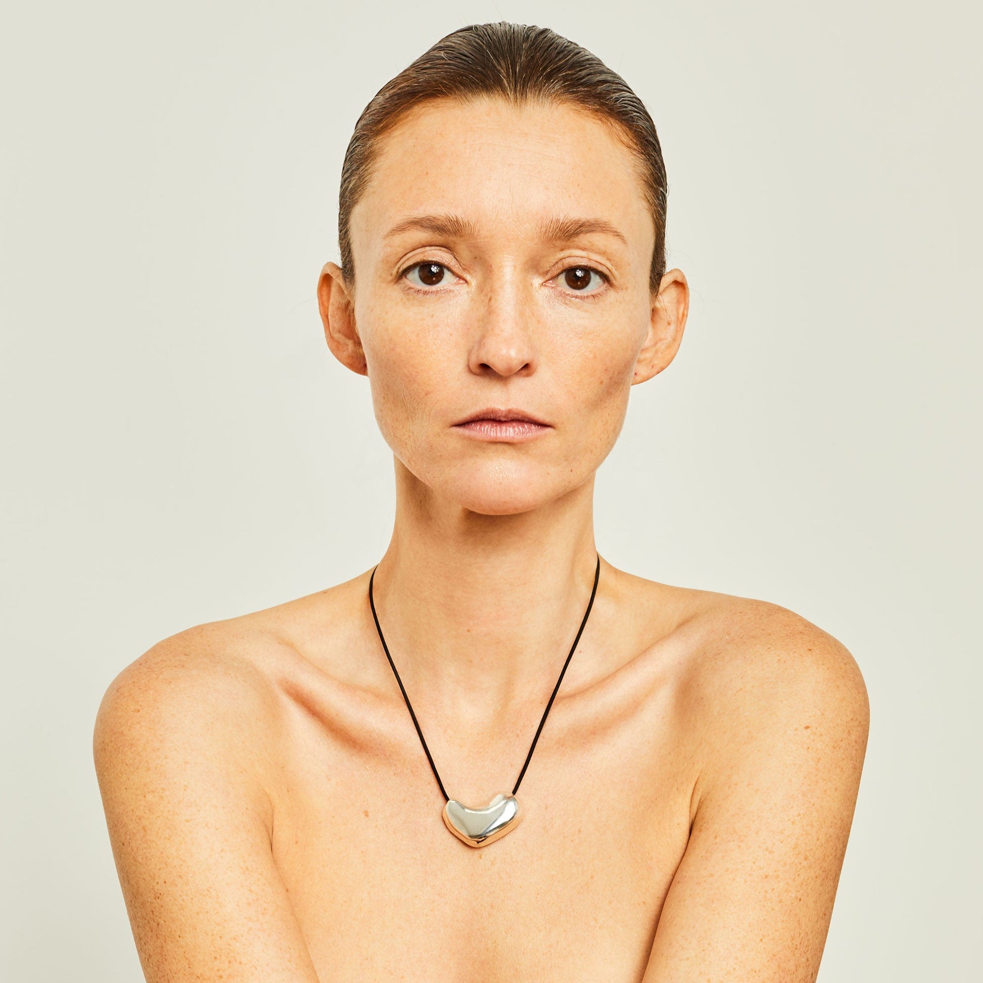 Woman wearing AGMES .925 Sterling Silver Sculpted Heart Pendant on Black Suede Cord. 