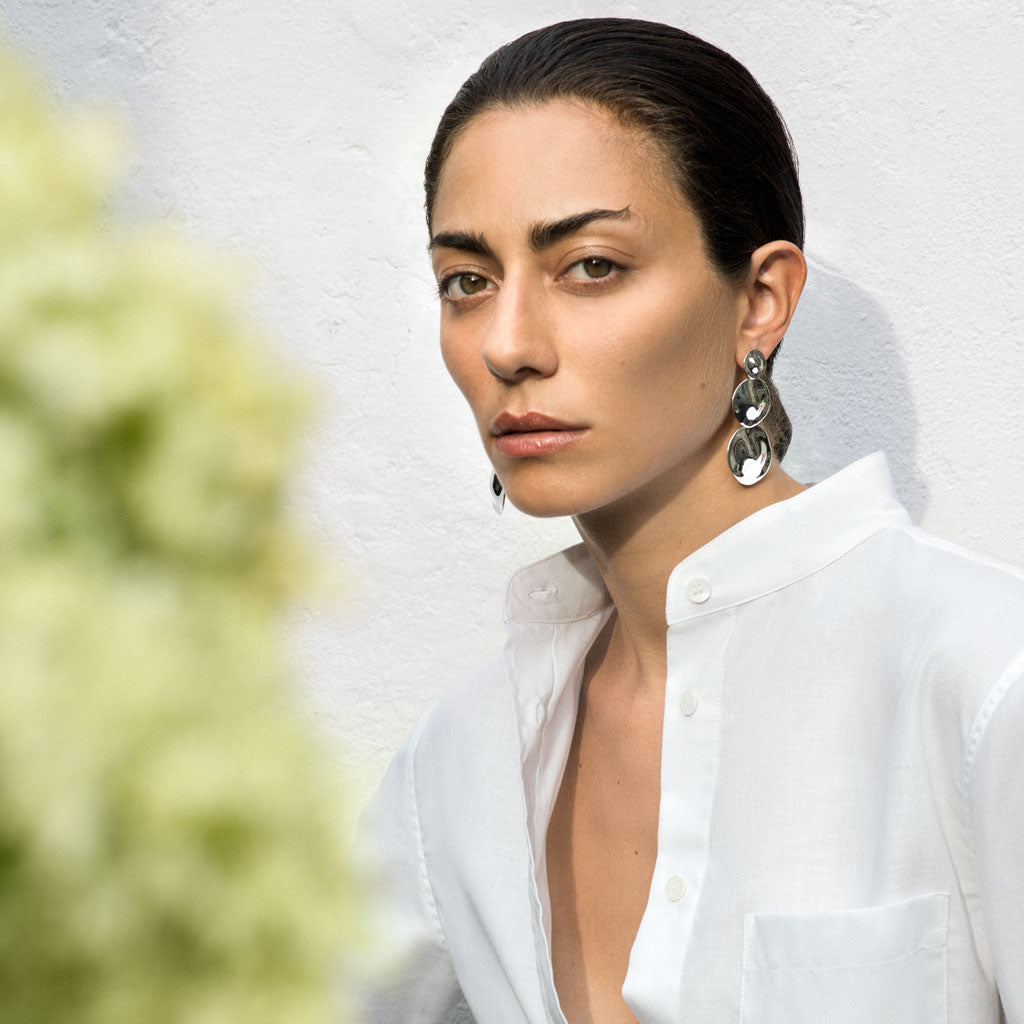 Woman wearing AGMES 0.925 sterling silver long circular round triple drop earrings.