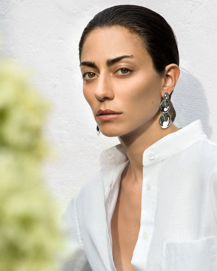 Woman wearing AGMES 0.925 sterling silver long circular round triple drop earrings.