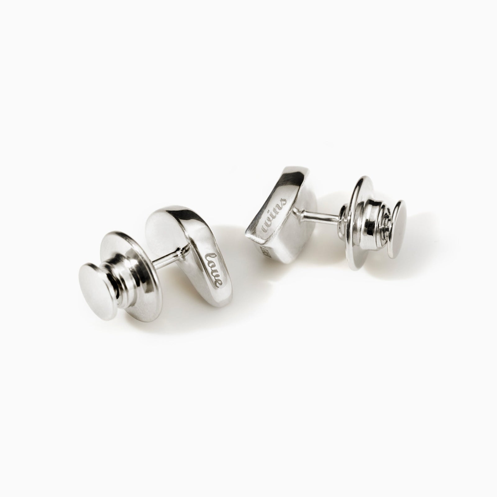 AGMES .925 sterling silver sculptural heart Sum of Parts Tie Tacks engraved with "love wins" on white background.