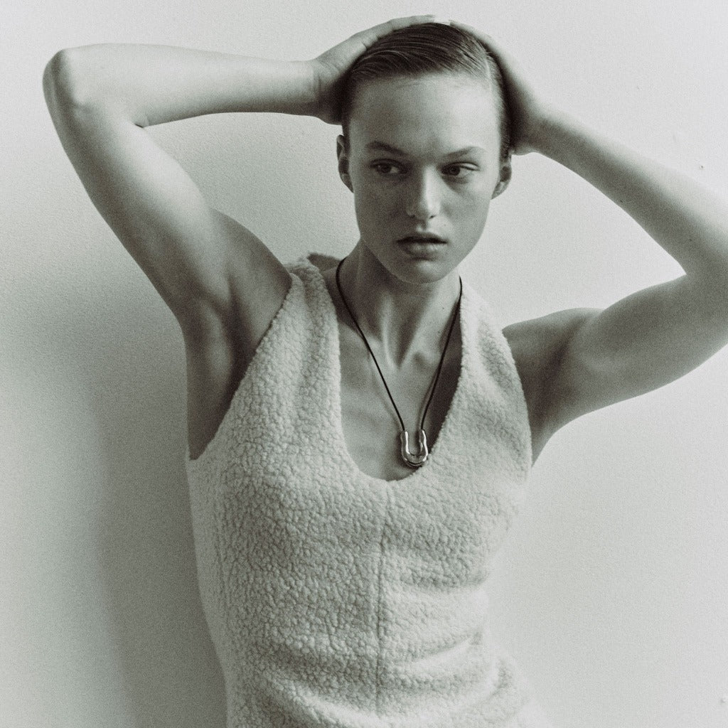 Woman wearing AGMES 0.925 sterling silver wishbone pendant on black suede cord 