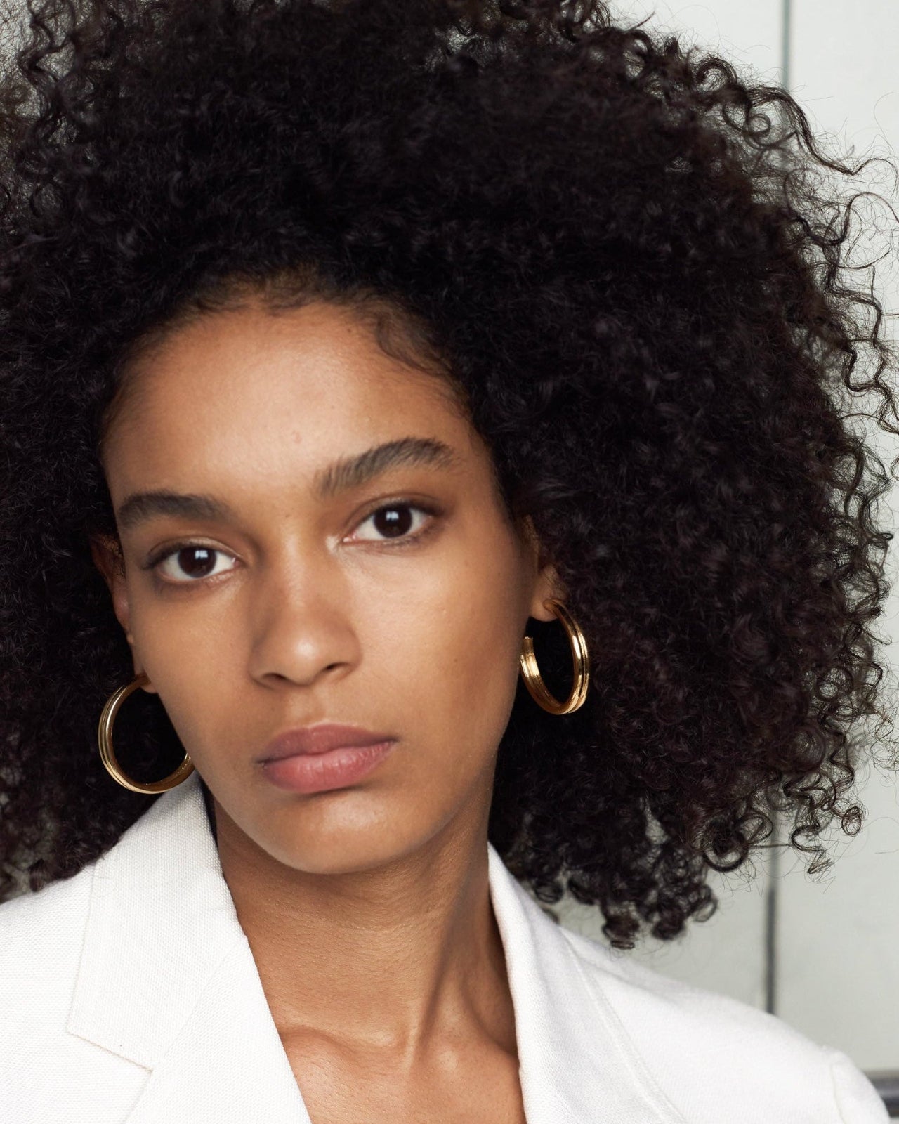 Woman wearing AGMES 18k gold vermeil double ridged large hoop earrings.