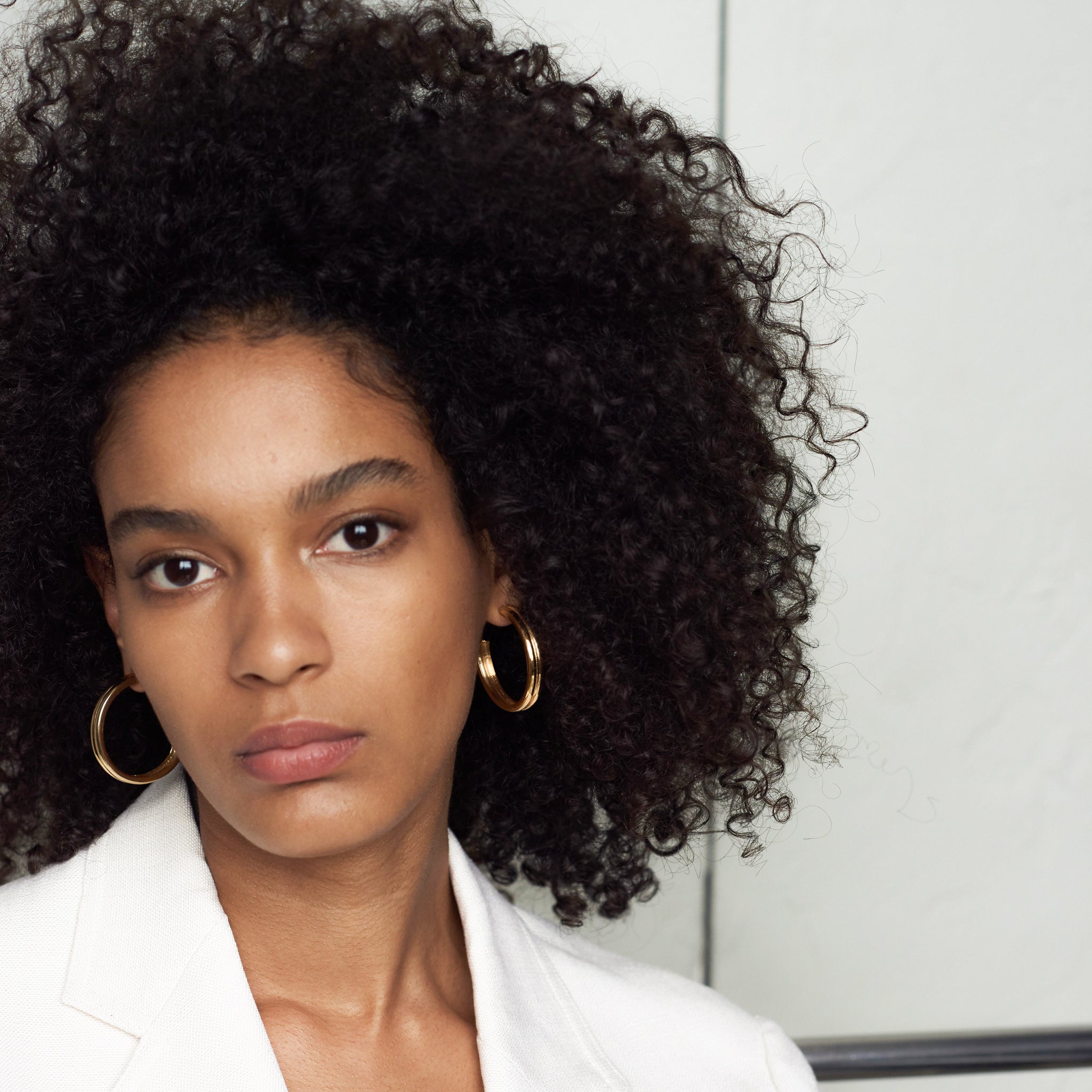 Woman wearing AGMES 18k gold vermeil double ridged large hoop earrings.