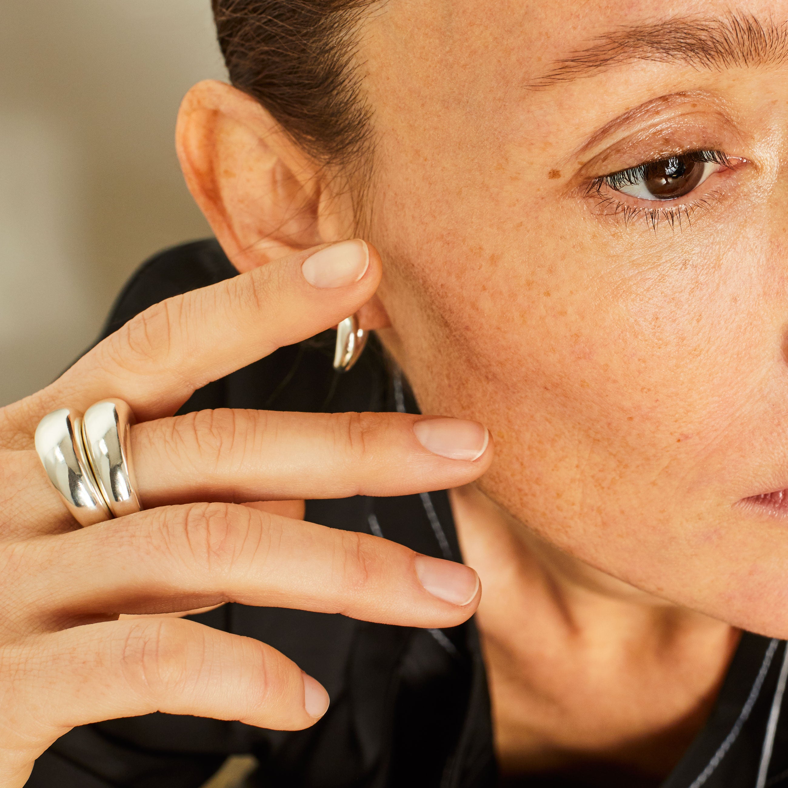 Person wearing AGMES 0.925 sterling silver mini hoop earrings.