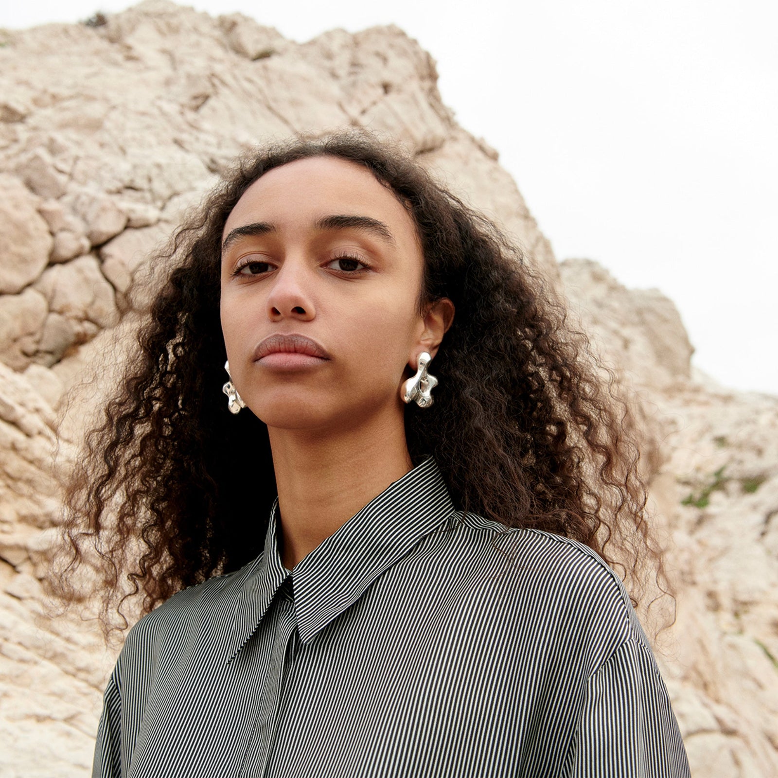 Woman wearing AGMES 0.925 sterling silver sculpted earrings. Simone Bodmer-Turner.
