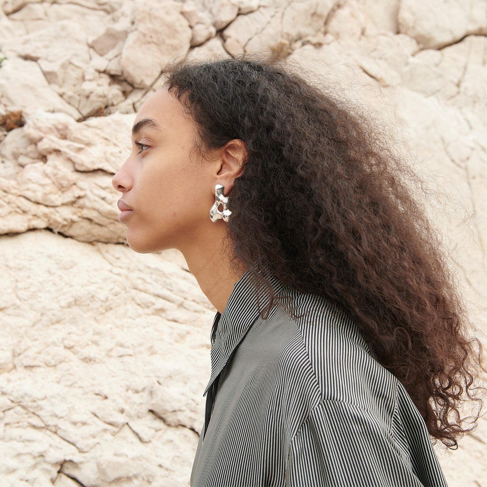 Woman wearing AGMES 0.925 sterling silver sculpted earrings. Simone Bodmer-Turner.
