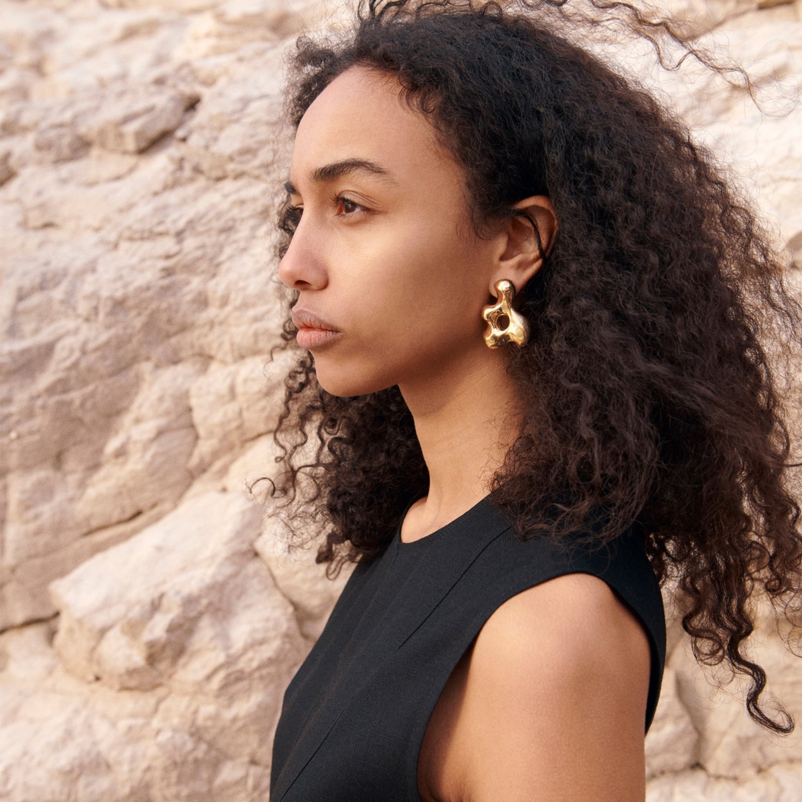 Woman wearing AGMES 18k gold vermeil sculpted earrings. Simone Bodmer-Turner.