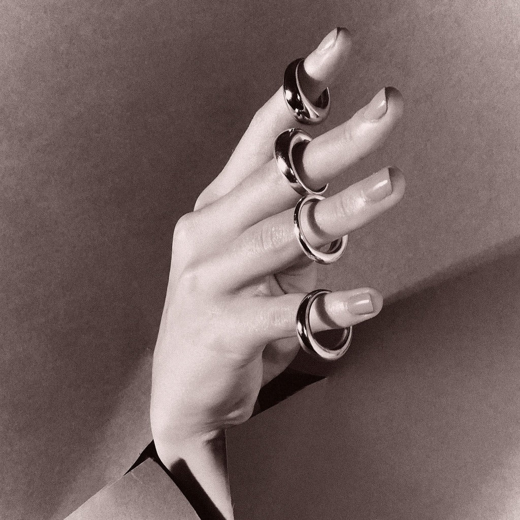 Hand wearing multiple AGMES .925 Sterling Silver Thin Domed Rings. 