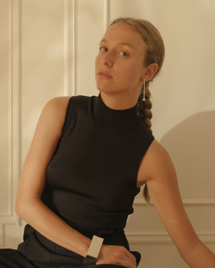 Model wearing AGMES .925 sterling silver long thin Drop Earrings with back shirt.