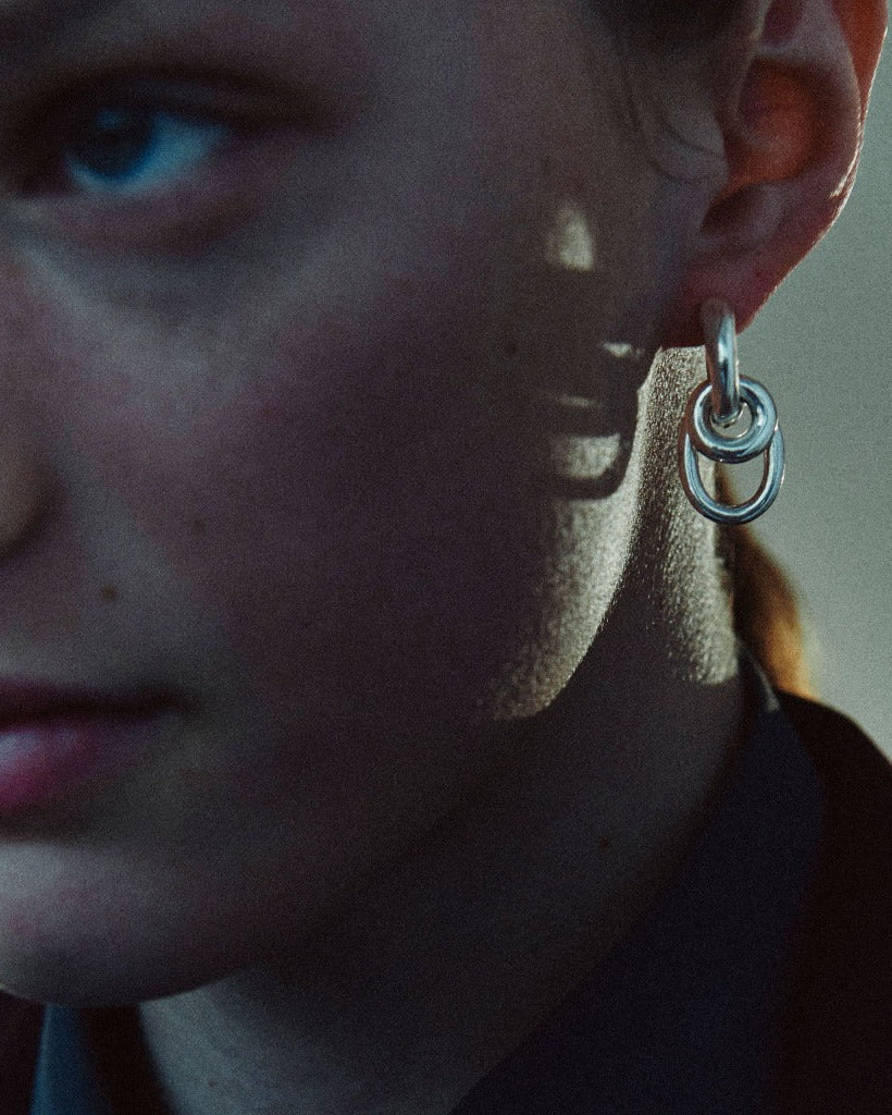 Woman wearing AGMES 0.925 sterling silver double drop hoop earrings.