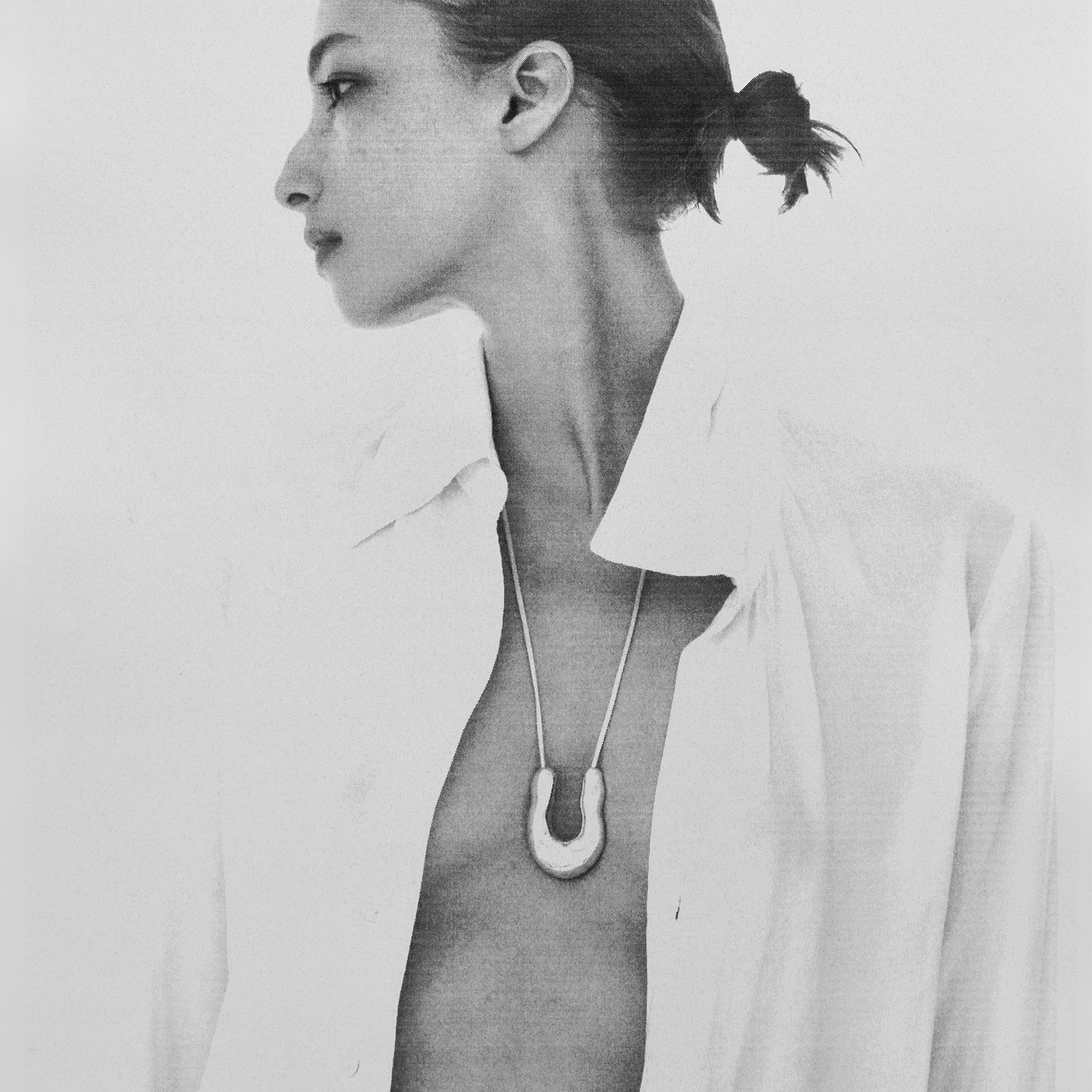 Woman wearing AGMES 18K Gold Vermeil Large Wishbone Pendant on Ivory Satin Cord.  