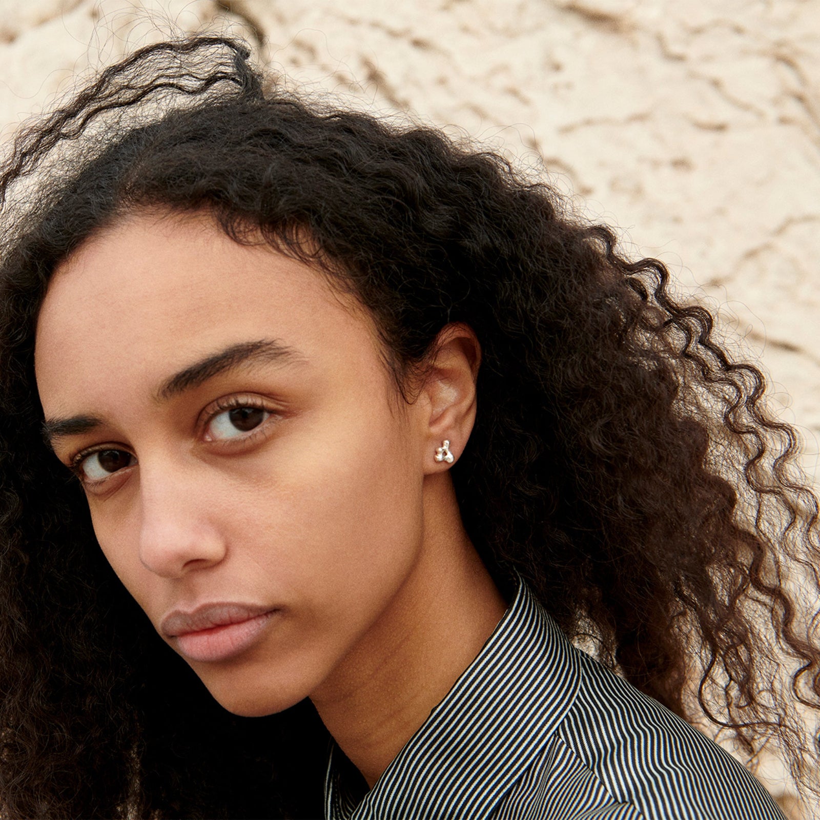 Woman wearing AGMES 0.925 sterling silver sculpted mini stud earrings. Simone Bodmer-Turner.