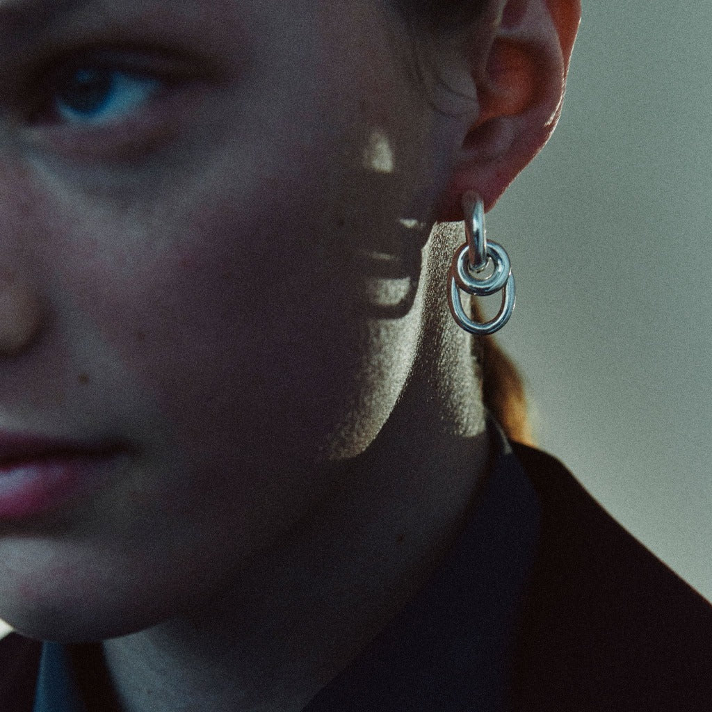 Woman wearing AGMES 0.925 sterling silver double drop hoop earrings.