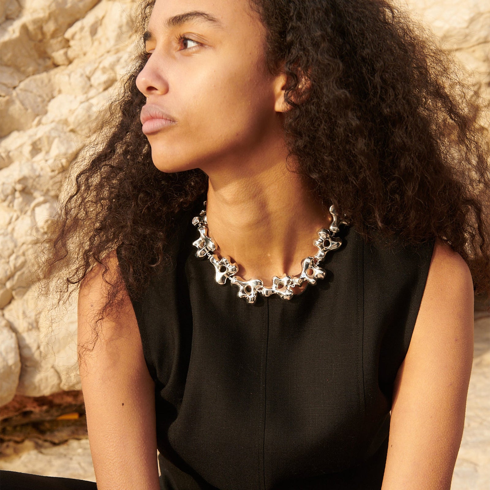 Model wearing AGMES .925 sterling silver sculptural collar Simone Necklace with black top.