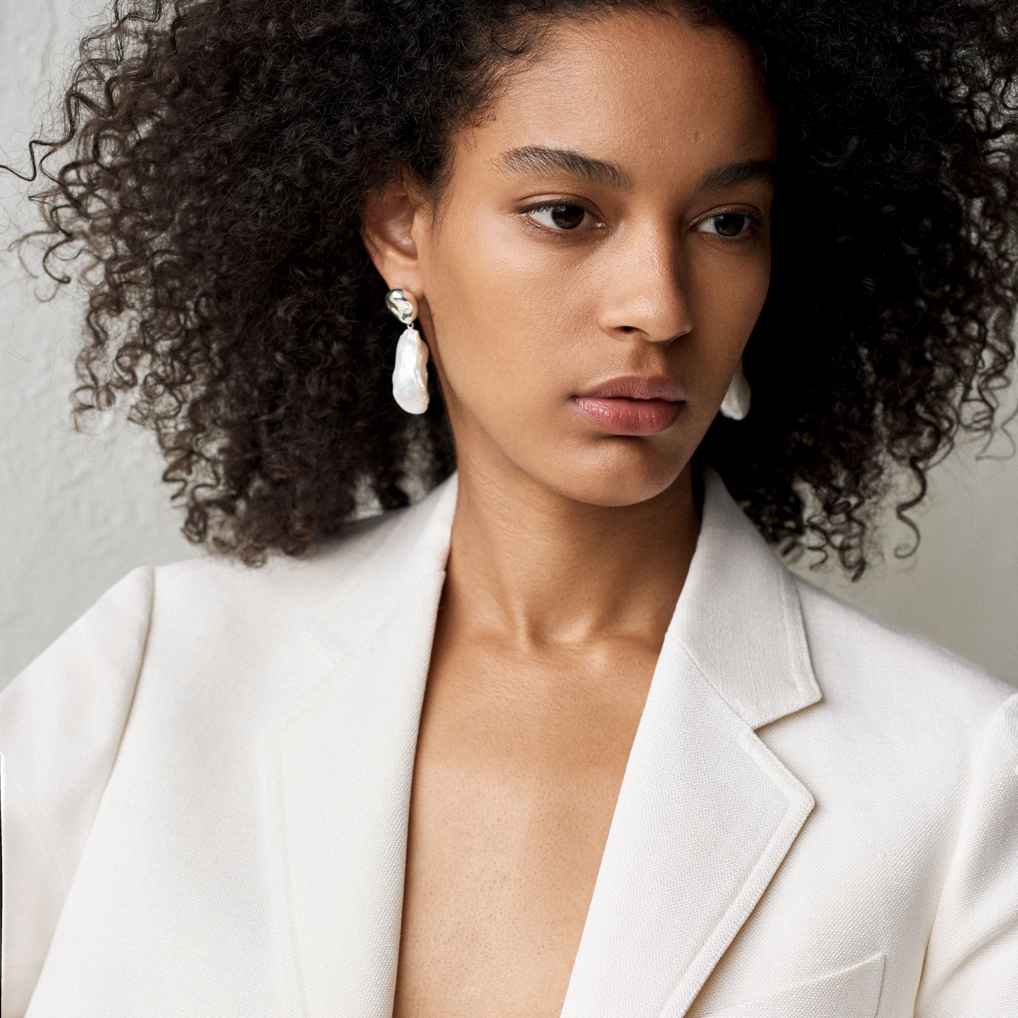 Woman wearing AGMES 0.925 sterling silver earrings with freshwater pearl drop.