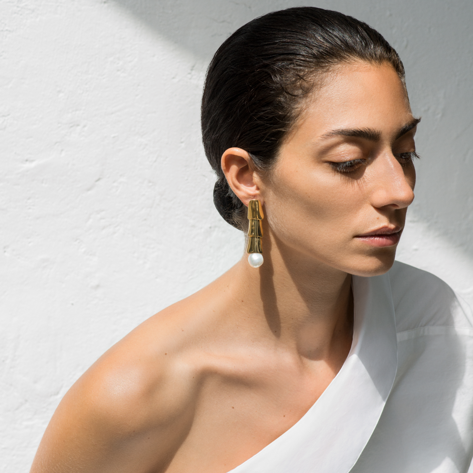 Woman wearing AGMES 18k gold vermeil layered long earrings with freshwater pearl.